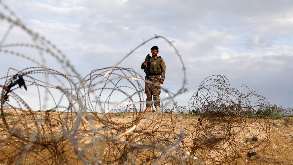 An Afghan National Army (ANA) soldier stands guard at a checkpoint outside Bagram prison, ahead of the release of 100 Taliban prisoners, north of Kabul