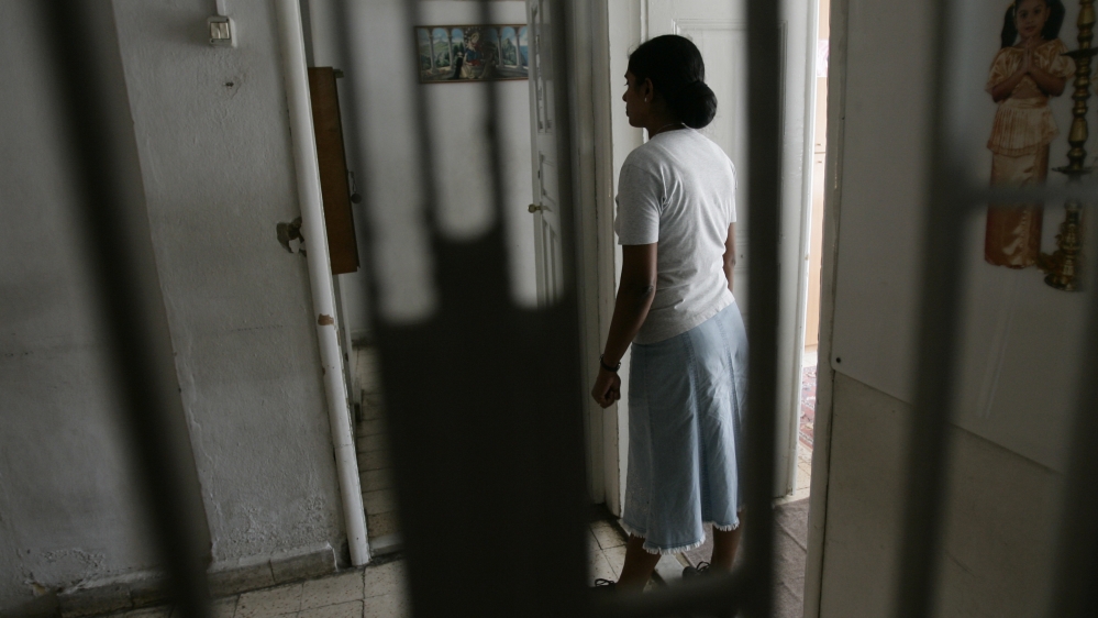 A foreign domestic worker walks in a shelter run by Caritas in Dora