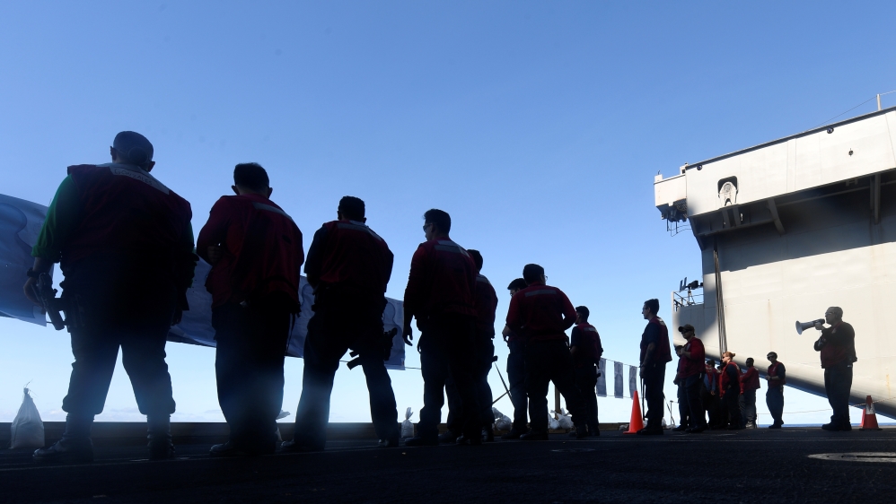 U.S. Navy sailors participate in a small arms qualification aboard the aircraft carrier USS Theodore Roosevelt