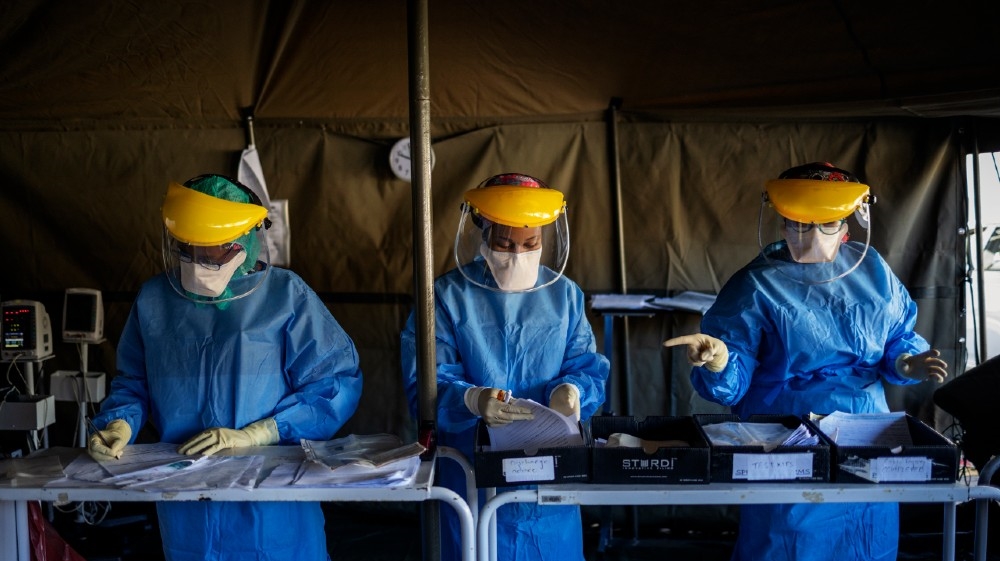 Health workers fill out documents before performing tests for COVID-19 coronavirus on other health workers at the screening and testing tents set up at the Charlotte 