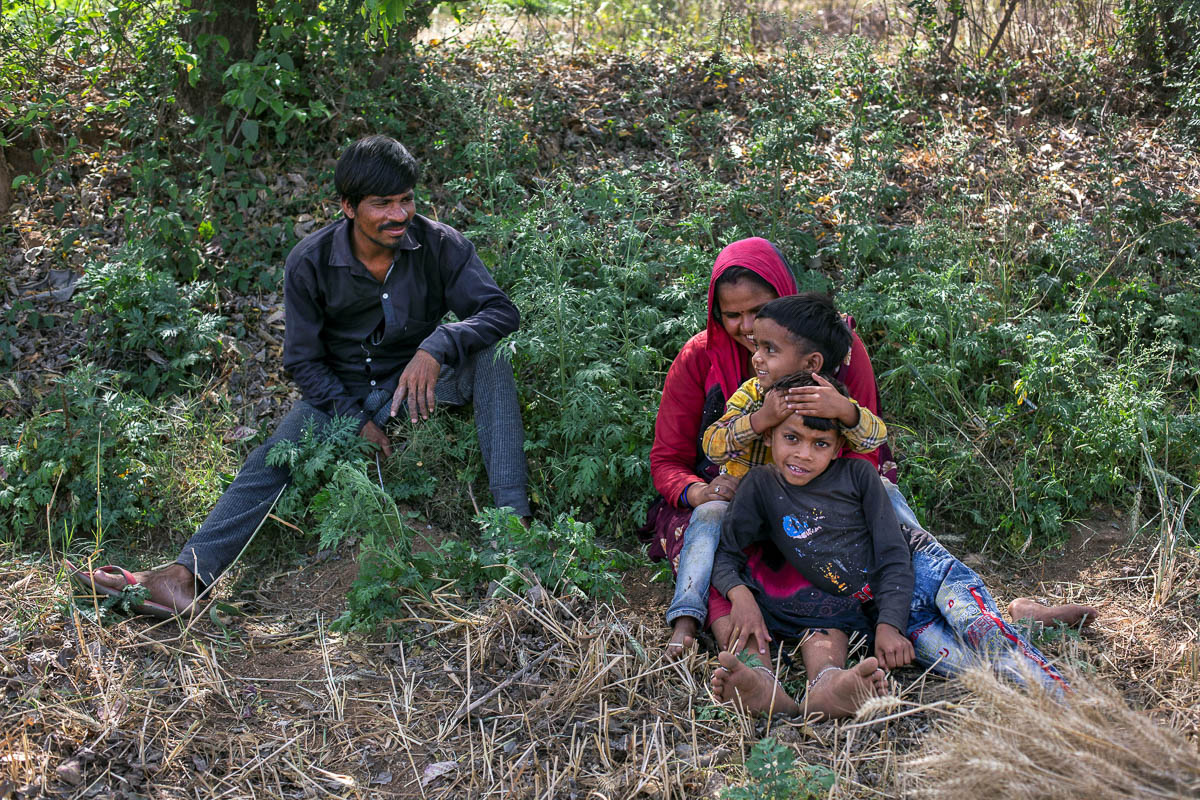 Dayaram Kushwaha and Gyanvati, migrant workers who returned home from New Delhi, play with their sons Mangal and Shivam as they take a break from harvesting wheat, during nationwide lockdown in India