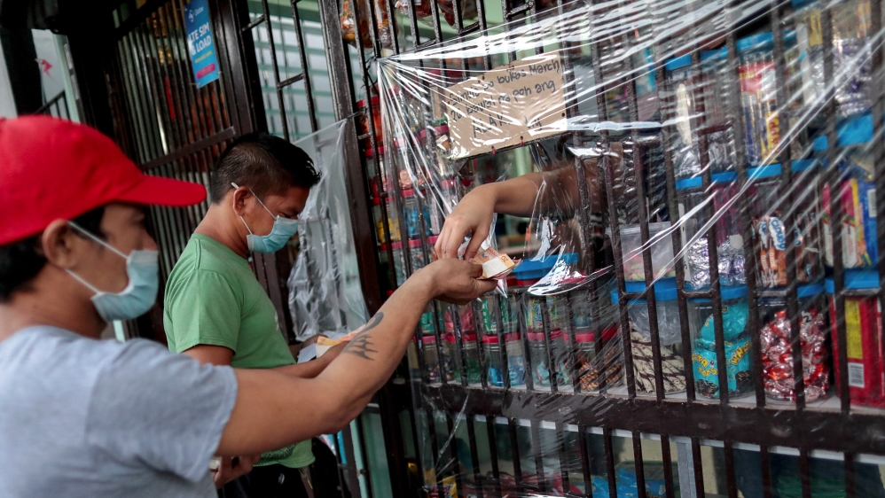 Shops install a makeshift plastic barrier as a protection from coronavirus disease, in Quezon City