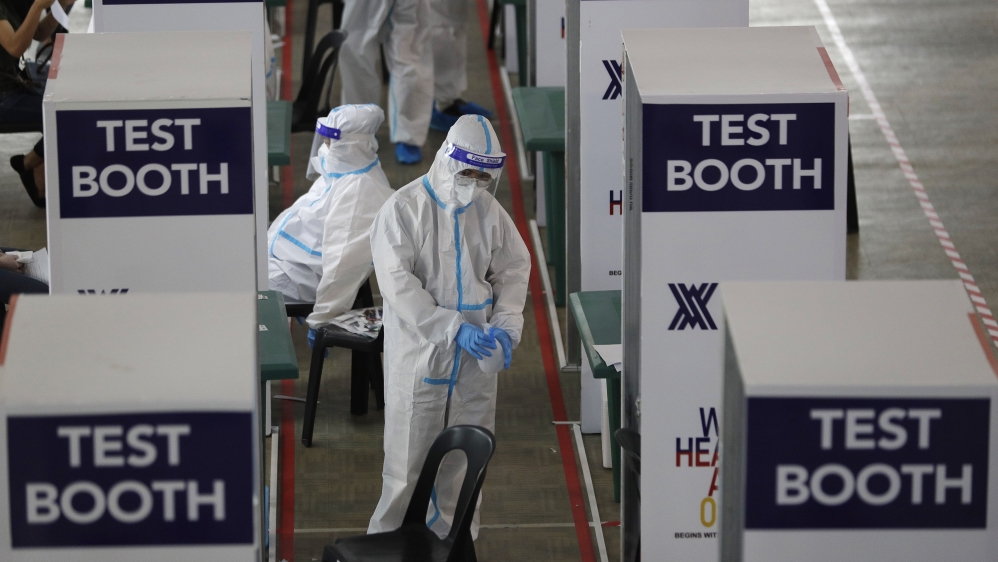 Health workers wait at a COVID-19 testing center at the Palacio de Manila during an enhanced community quarantine to prevent the spread of the new coronavirus on Monday, May 11, 2020 in Manila, Philip