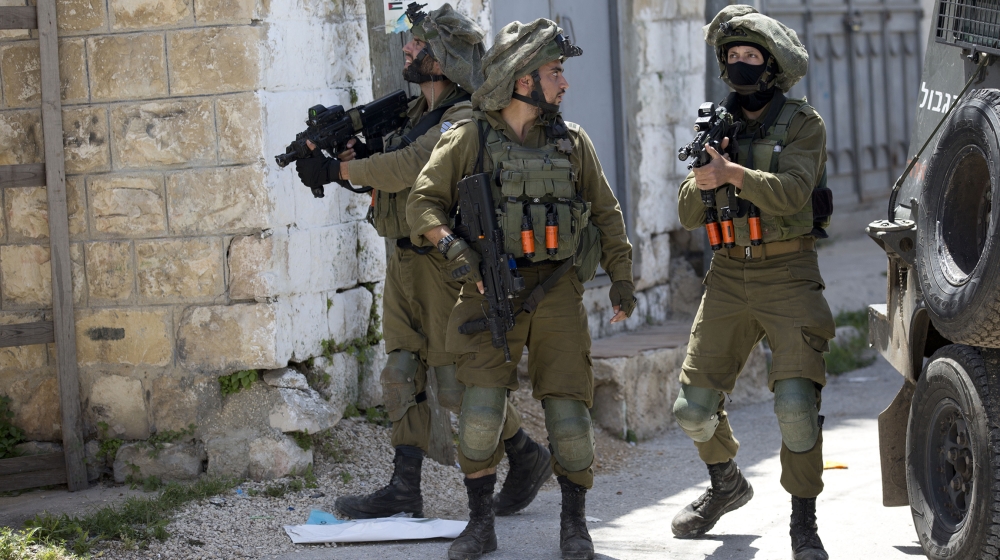 Israeli soldiers patrol after a soldier was killed when a rock thrown off a rooftop struck him in the head g during an arrest raid, in the village of Yabad near the West Bank city of Jenin, Tuesday, M