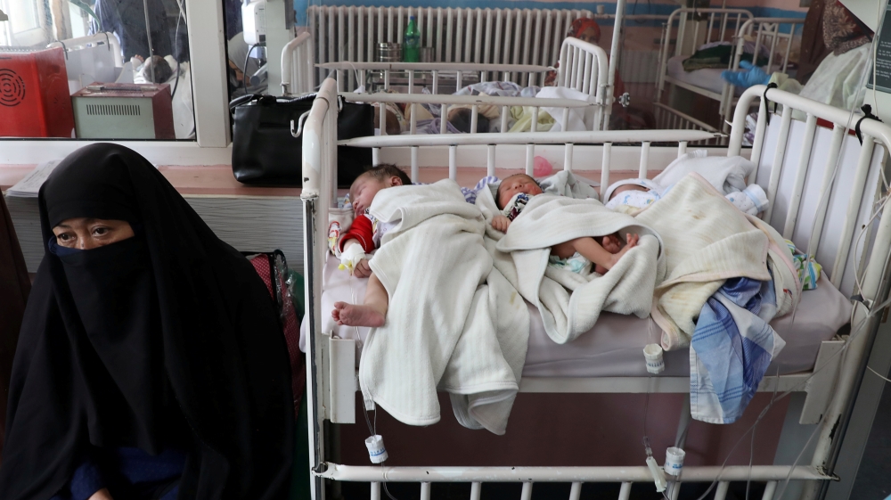 Newborn children who lost their mothers lie on a bed at a Kabul hospital