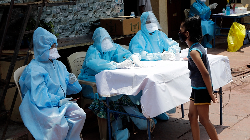 Doctors speak with a girl during a free medical camp in Dharavi, one of Asia's largest slums, during lockdown to prevent the spread of the new coronavirus in Mumbai, India, Saturday, April 18, 2020. I