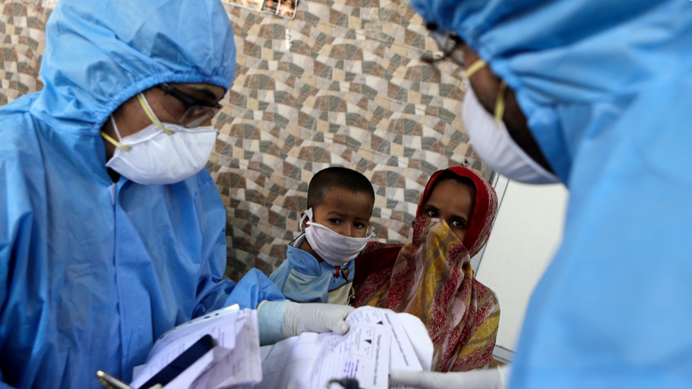Doctors interact with people at a slum area during lockdown to control the spread of the new coronavirus in Mumbai, India, Tuesday, April 7, 2020. The new coronavirus causes mild or moderate symptoms