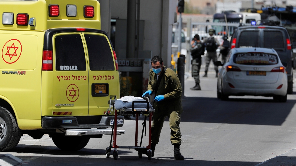 An Israeli soldier wheels a stretcher at the scene of an incident at Qalandia checkpoint in the Israeli-occupied West Bank May 12, 2020. REUTERS/Ammar Awad