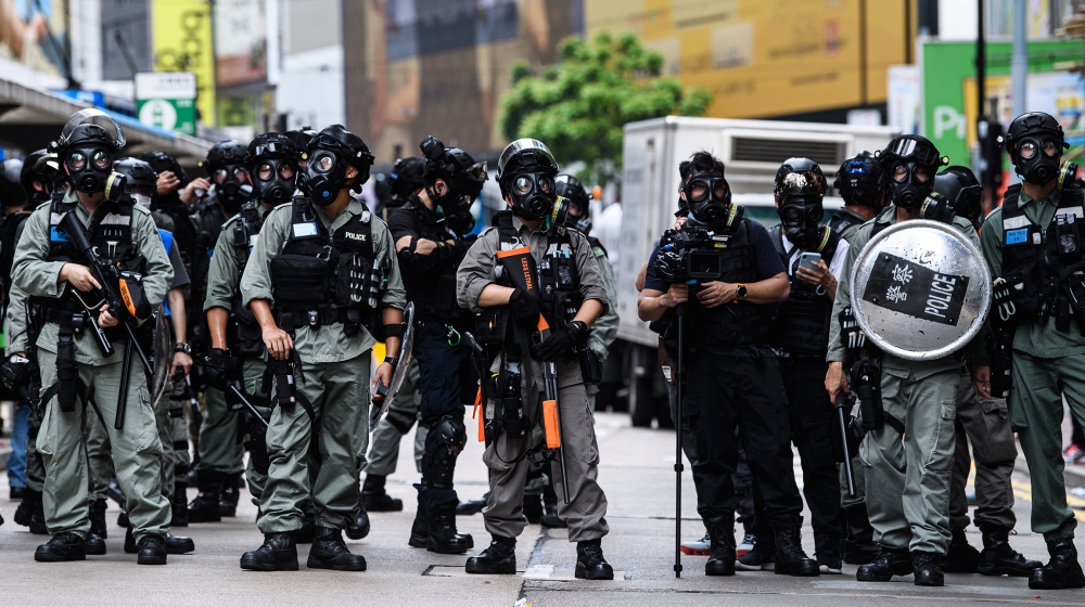 Riot police stand guard in a road as protesters attend a pro-democracy rally against a proposed new security law in Hong Kong on May 24, 2020. Police fired tear gas and water cannon at thousands of Ho
