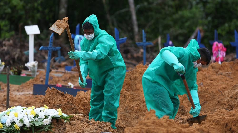 Cemetary workers dig graves for victims and suspected victims of the COVID-19 coronavirus pandemic at the Nossa Senhora cemetary in Manaus, Amazon state, Brazil on May 6, 2020. MICHAEL DANTAS / AFP