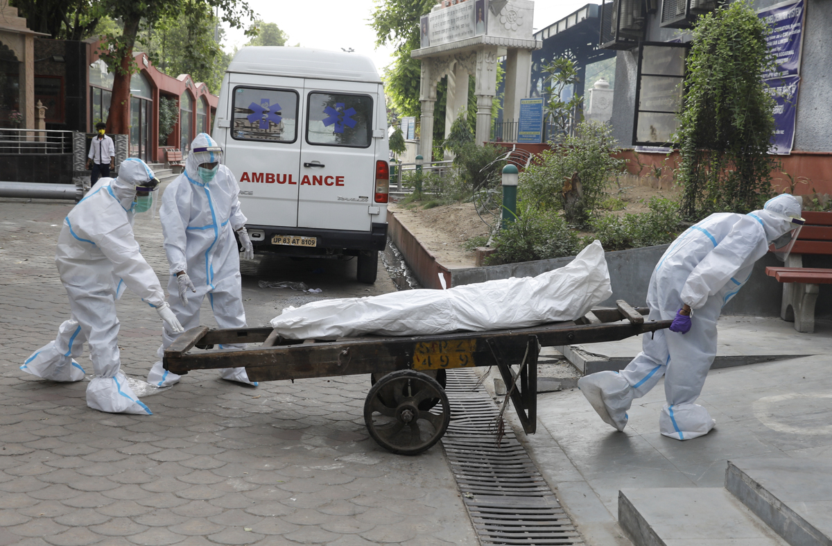 Health workers carry the body of a man who died due to the coronavirus disease (COVID-19) for his cremation, at a crematorium in New Delhi, India June 28, 2020. REUTERS/Adnan Abidi