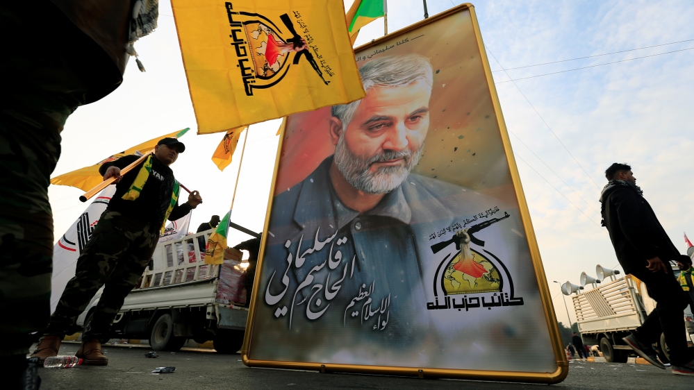 Kataib Hezbollah Iraqi militia hold the picture of the Iranian Major-General Qassem Soleimani, as they gather ahead of the funeral of the Iraqi militia commander Abu Mahdi al-Muhandis, in Baghdad