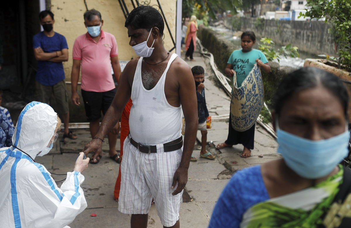 A healthcare worker measures the pulse of a resident during a check-up camp for the coronavirus disease (COVID-19), in Mumbai, India June 28, 2020. REUTERS/Francis Mascarenhas