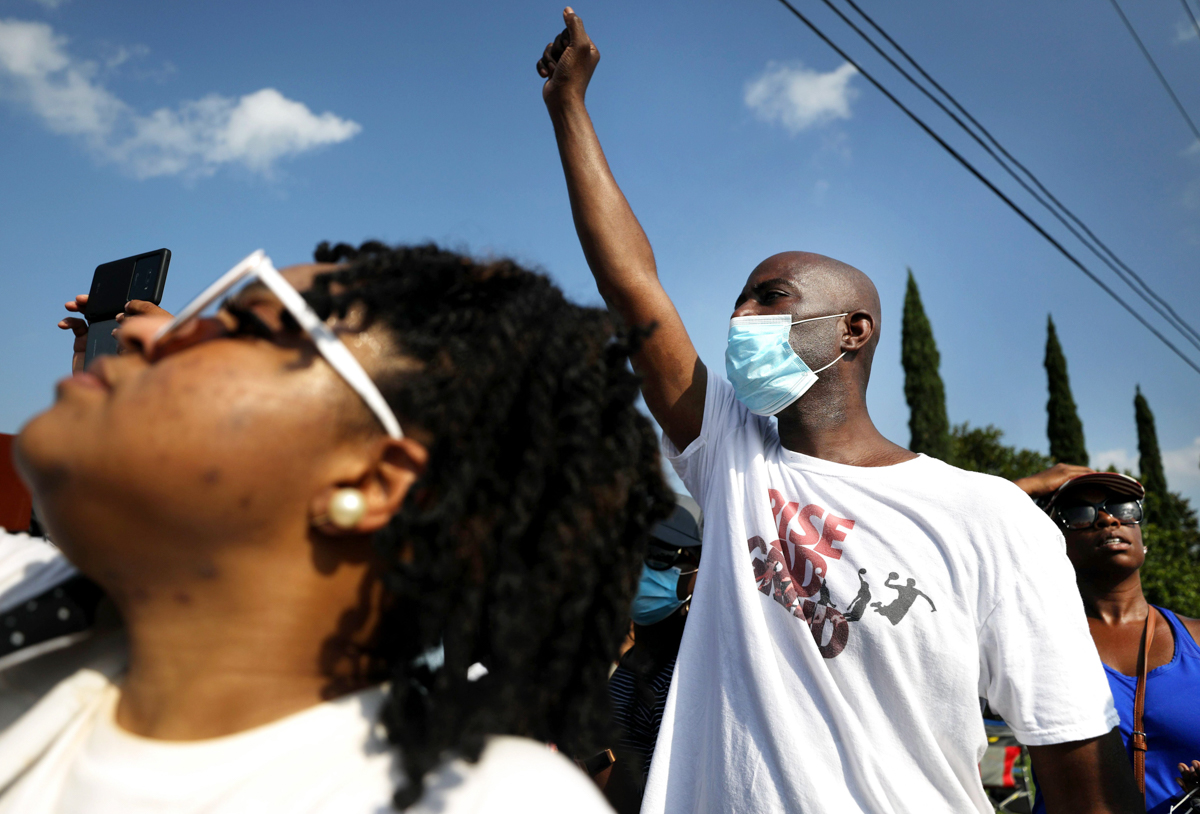 PEARLAND, TEXAS - JUNE 09: People watch the George Floyd funeral procession enter Houston Memorial Gardens Cemetery for burial on June 9, 2020 in Pearland, Texas. George Floyd died on May 25th when he