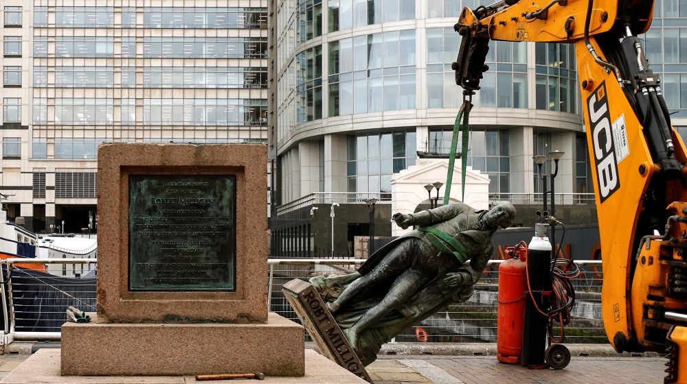 A statue of Robert Milligan is pictured being removed by workers outside the Museum of London Docklands near Canary Wharf, following the death of George Floyd who died in police custody in Minneapolis