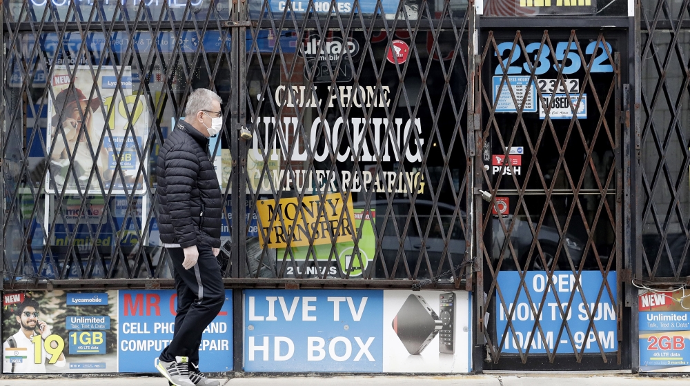 A man walks by a closed store during the COVID-19 in Chicago. Layoffs are declining and hiring is slowly picking up, yet it''s not really clear where the job market goes next. [File :Nam Y. Huh/AP Phot