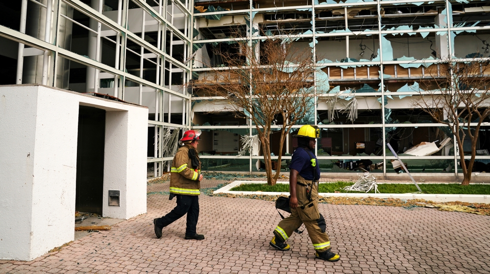 Firefighters walk in front of a damaged building after Hurricane Laura passed through Lake Charles, Louisiana, U.S. August 27, 2020. REUTERS/Elijah Nouvelage