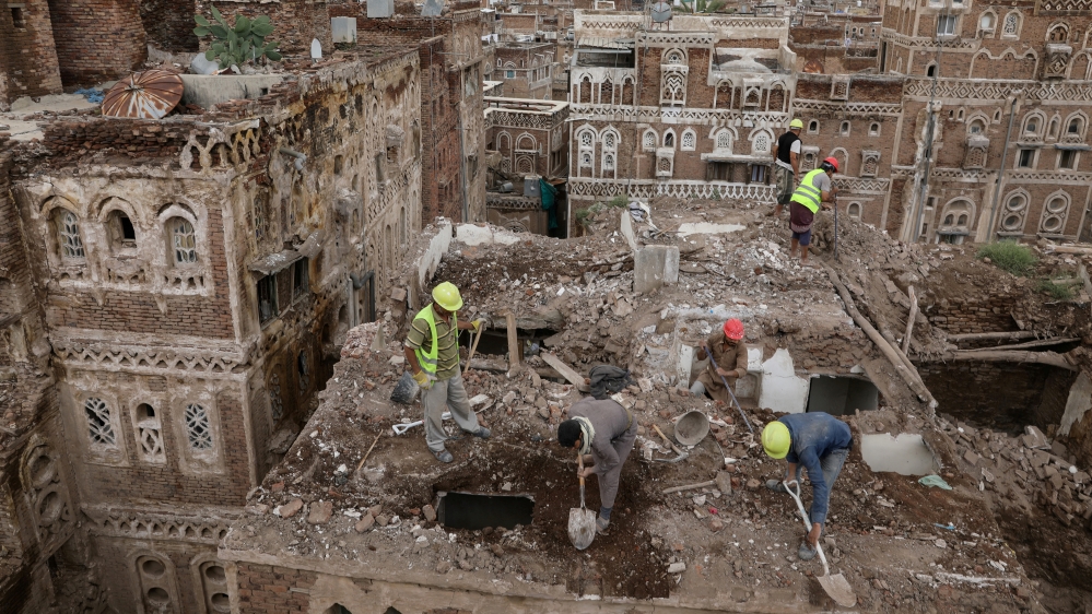 Workers demolish a building damaged by rain in the UNESCO World Heritage site of the old city of Sanaa