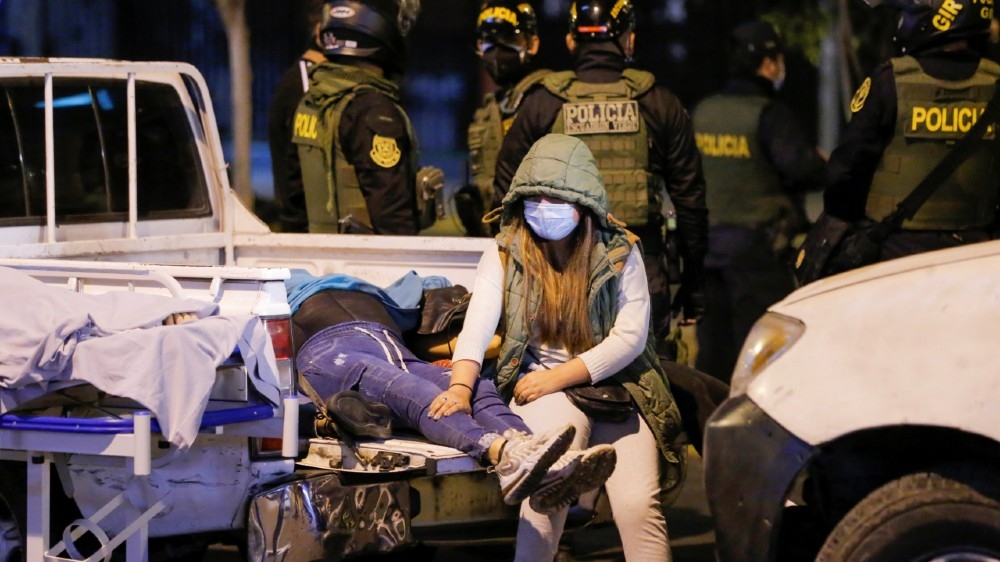 SENSITIVE MATERIAL. THIS IMAGE MAY OFFEND OR DISTURB A woman sits next to the bodies of people who died after police raided a nightclub for hosting a party in violation of the coronavirus 