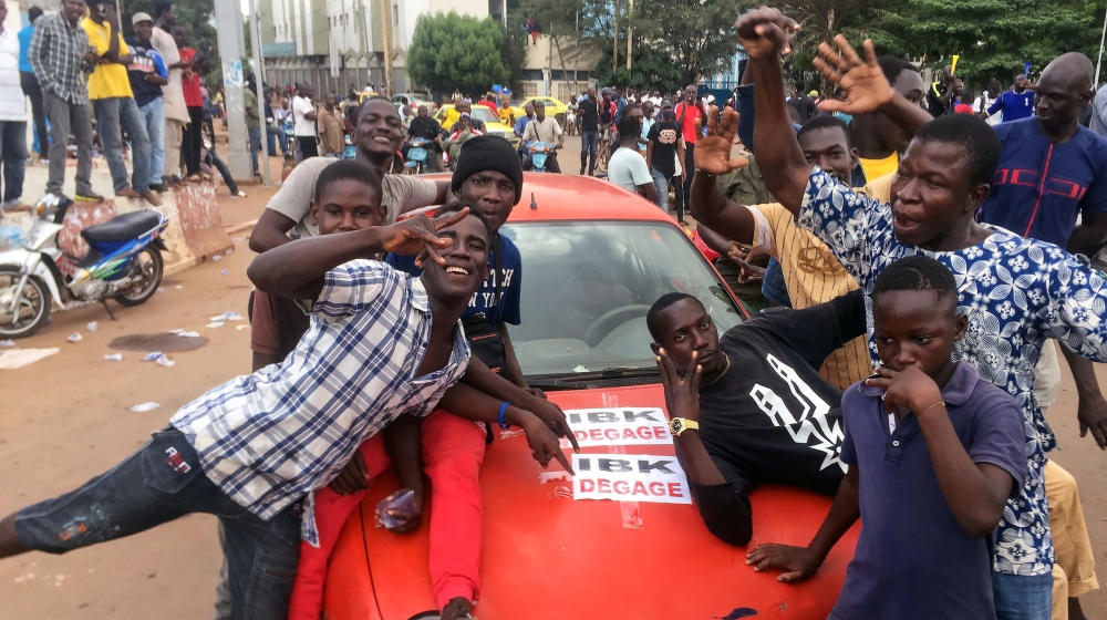 Opposition supporters react to the news of a possible mutiny of soldiers in the military base in Kati, outside the capital Bamako, at Independence Square in Bamako, Mali August 18, 2020. REUTERS/Rey B
