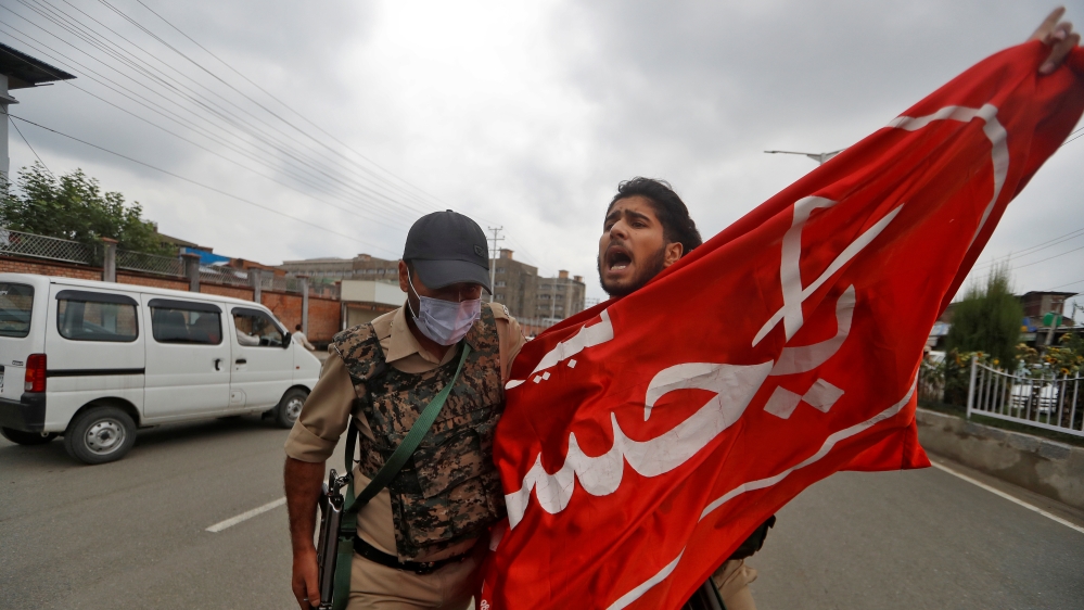 A Kashmir Shi'ite Mulsim shouts slogans as he is detained an Indan policeman while trying to participate in a Muharram procession, in Srinagar