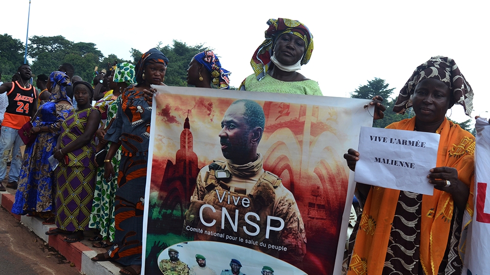 A woman holds a poster of Colonel Assimi Goita, the junta leader of the National Committee for the Salvation of the People (CNSP), as women gather to support a military transition while the junta lead