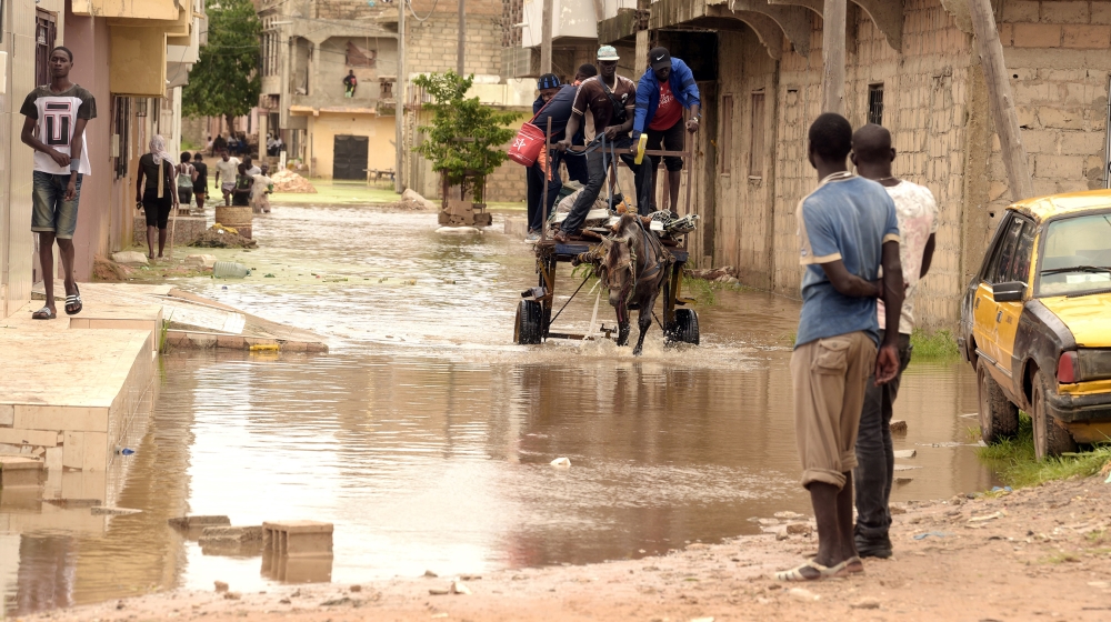 Residents transport their belongings with a horse pulling a cart through flood waters in the Keurs Massar area in Dakar on September 7, 2020 after heavy rains in Senegal. The Senegalese government cam