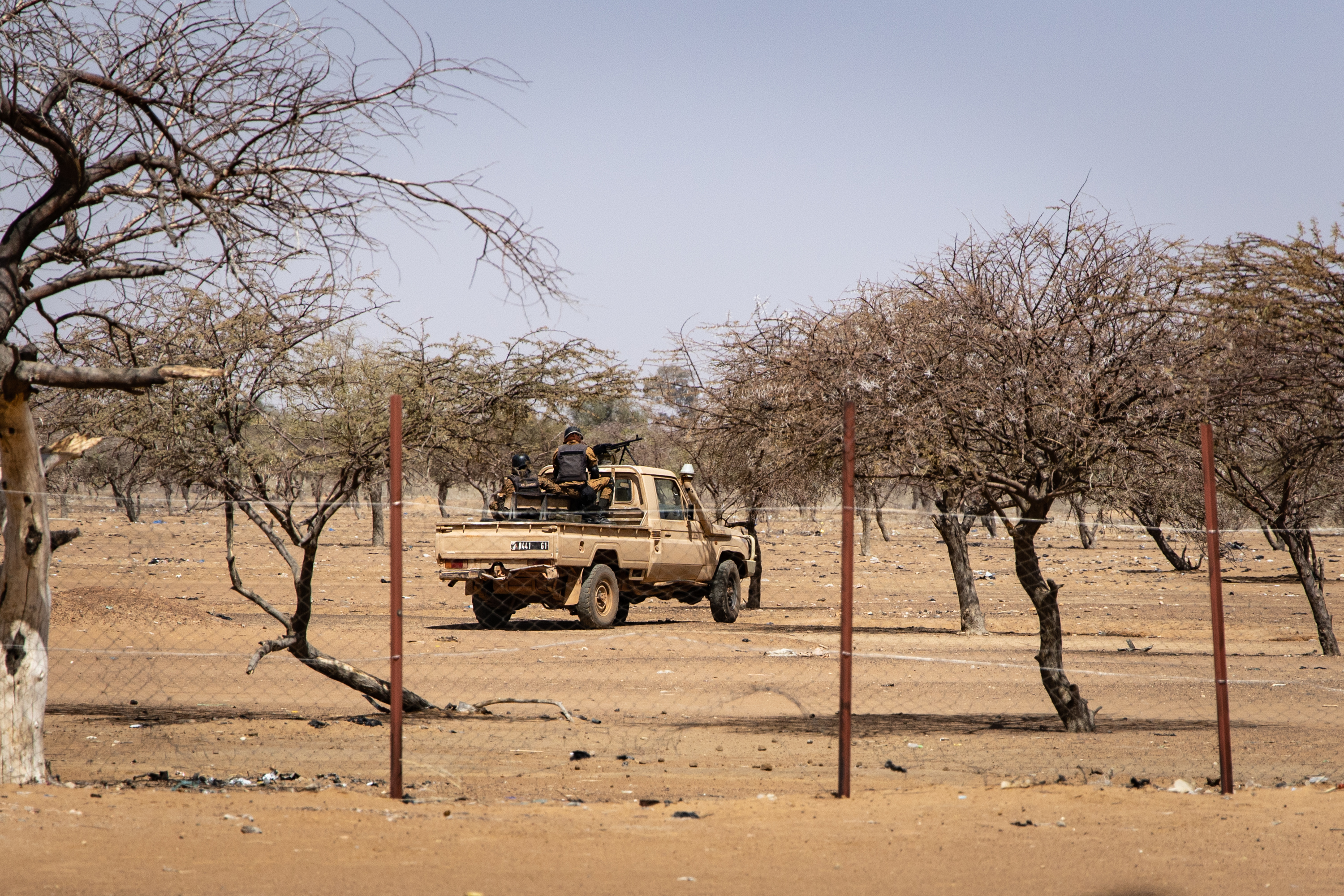 In a photo from February 2020, Burkina Faso soldiers patrol aboard a pick-up truck at a camp sheltering Malian refugees, in Dori [Olympia de Maismont/AFP]