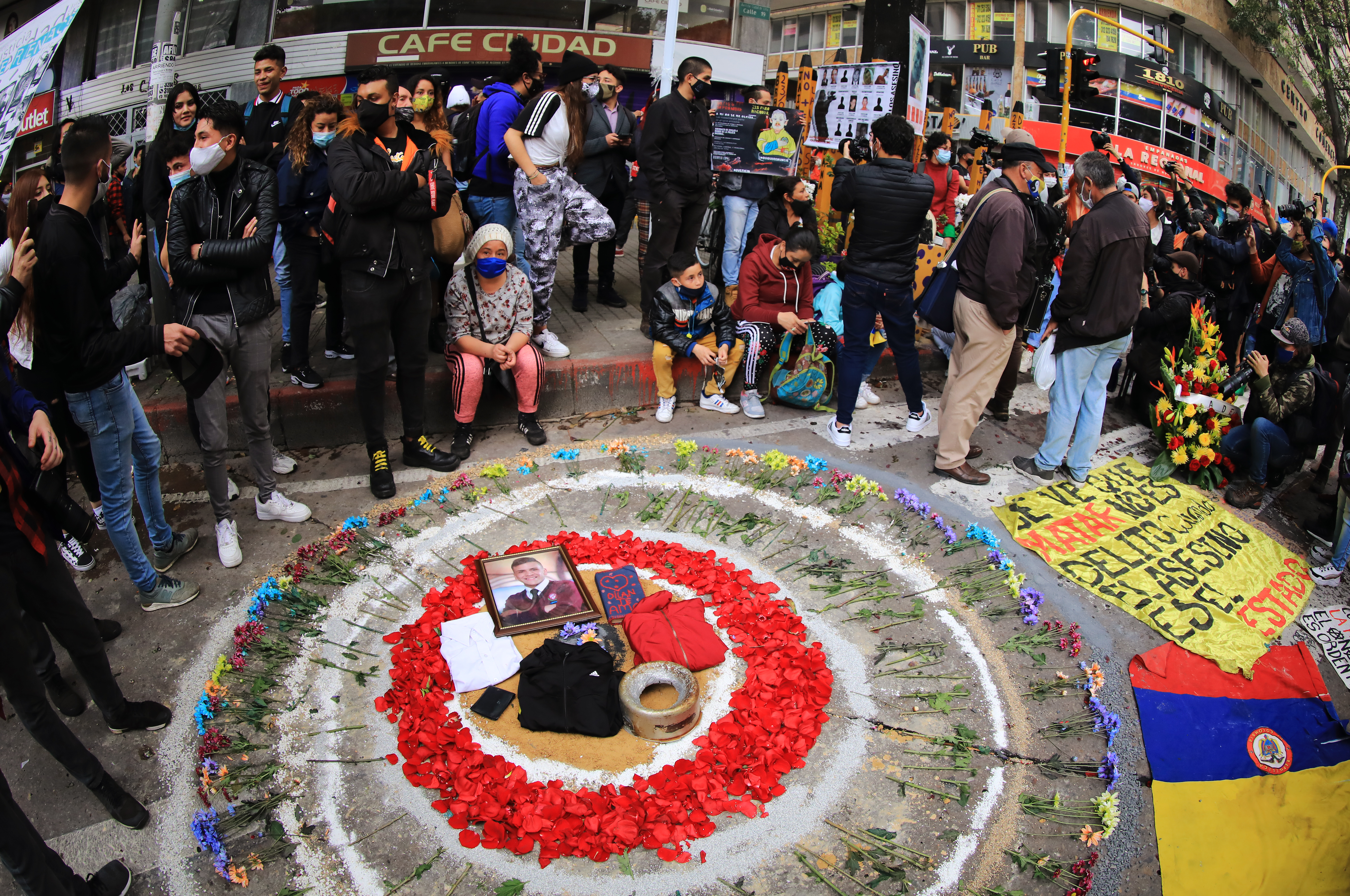 Rose petals form a circle surrounding a picture of Dilan Cruz on the site where he was shot during a protest to commemorate a year since his death in Bogota, Colombia, on November 23, 2020 [Daniel Munoz/AFP]