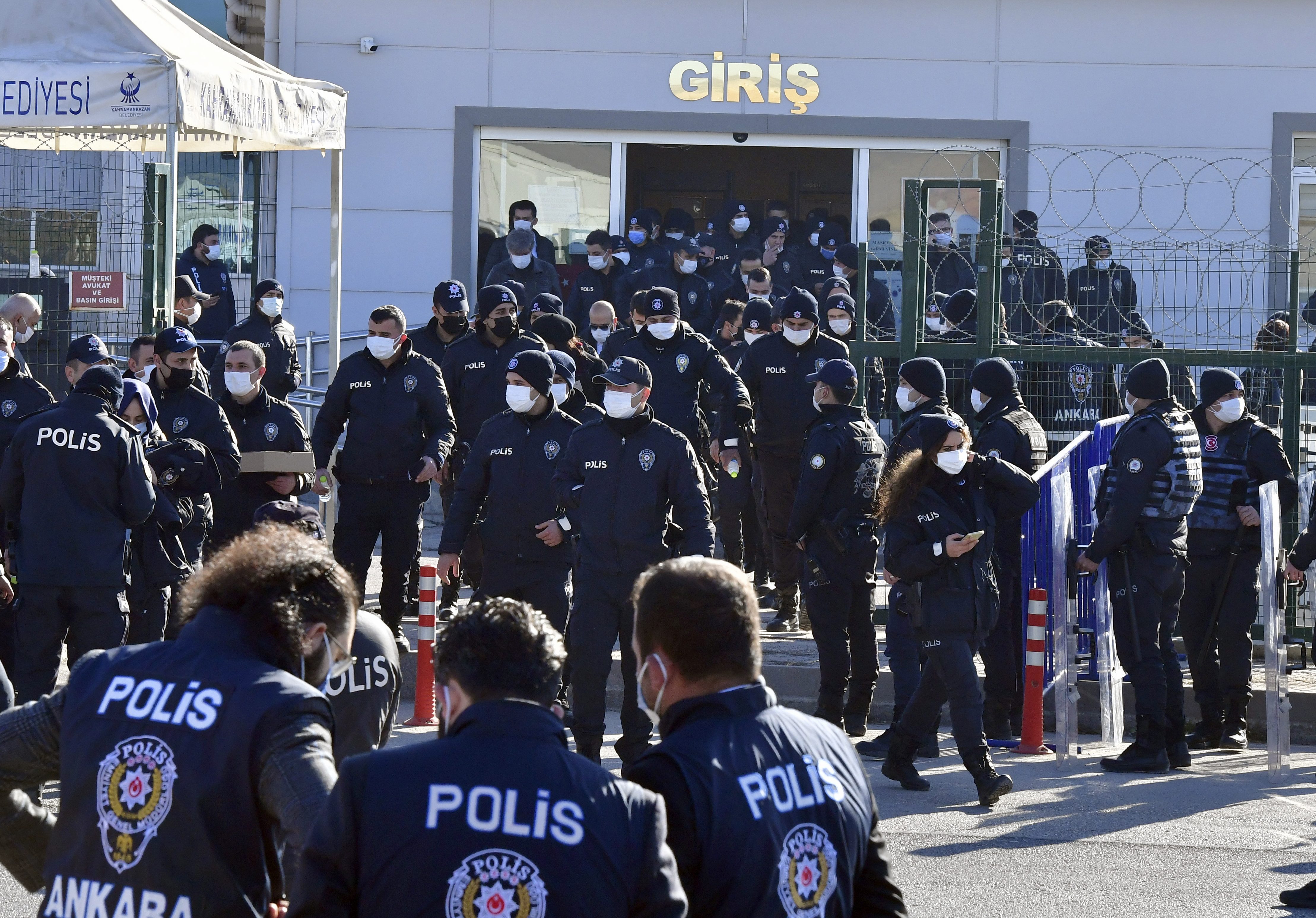 Riot police officers stand at the entrance of a courthouse during the trial of 475 defendants, including generals and fighter jet pilots, in Sincan, Ankara [AP Photo]