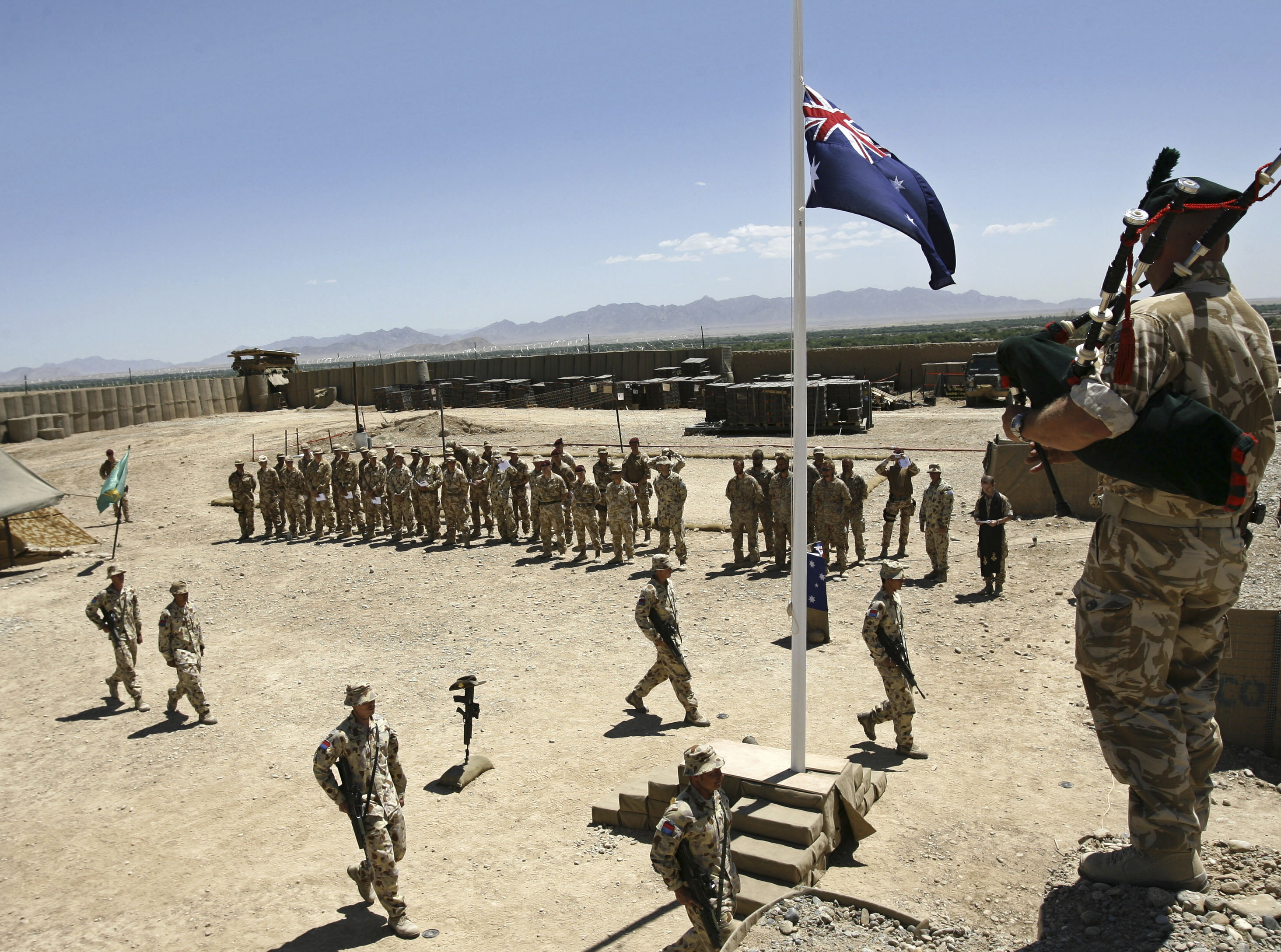 Australian and British troops stand at attention during an ANZAC day ceremony at Camp Armadillo in Afghanistan on April 25, 2008 [Reuters/Omar Sobhani]