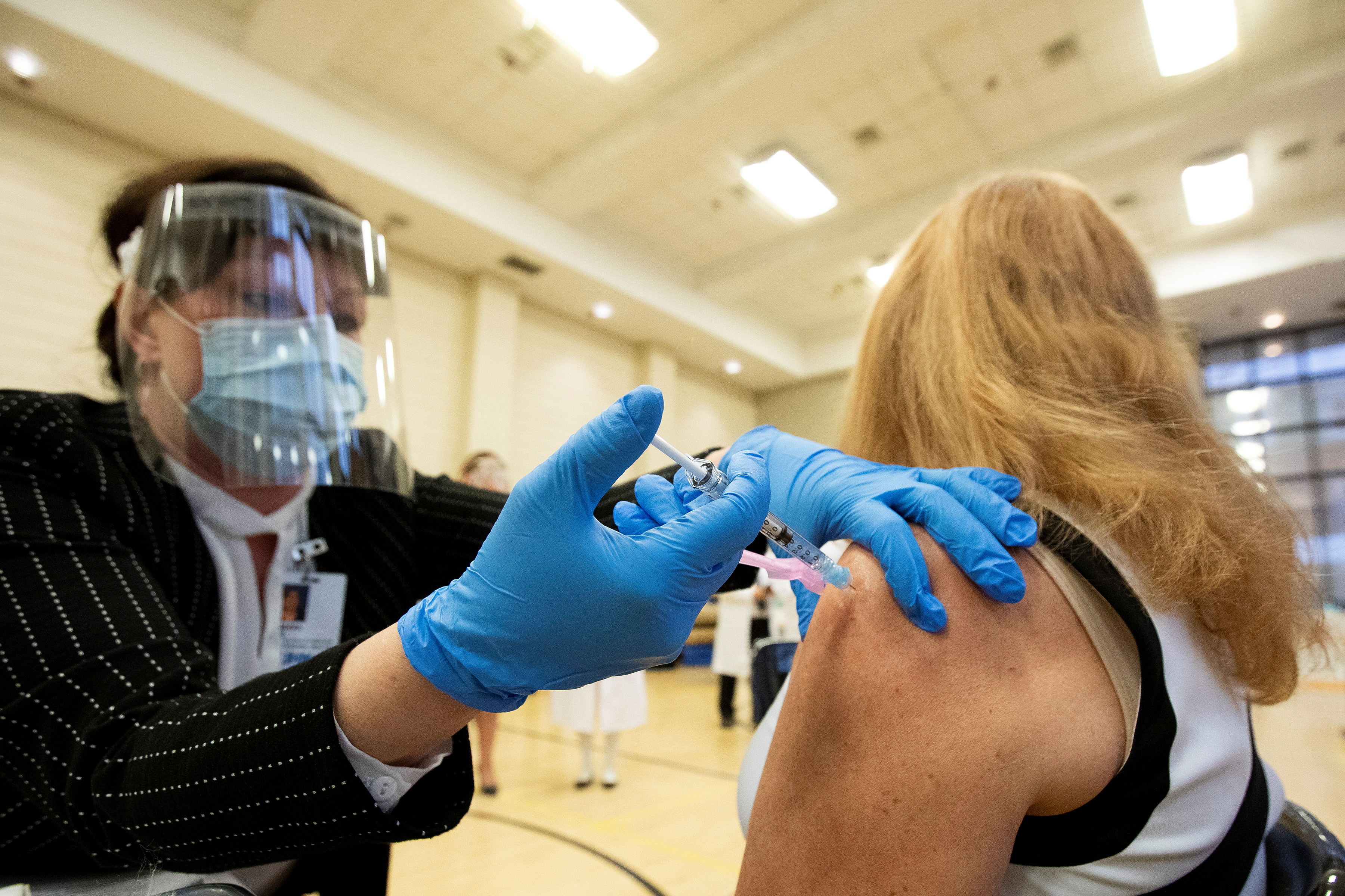 The first Pfizer-BioNTech COVID-19 vaccines were administered this week to health workers and residents of long-term care homes in Canada [Carlos Osorio/Reuters]