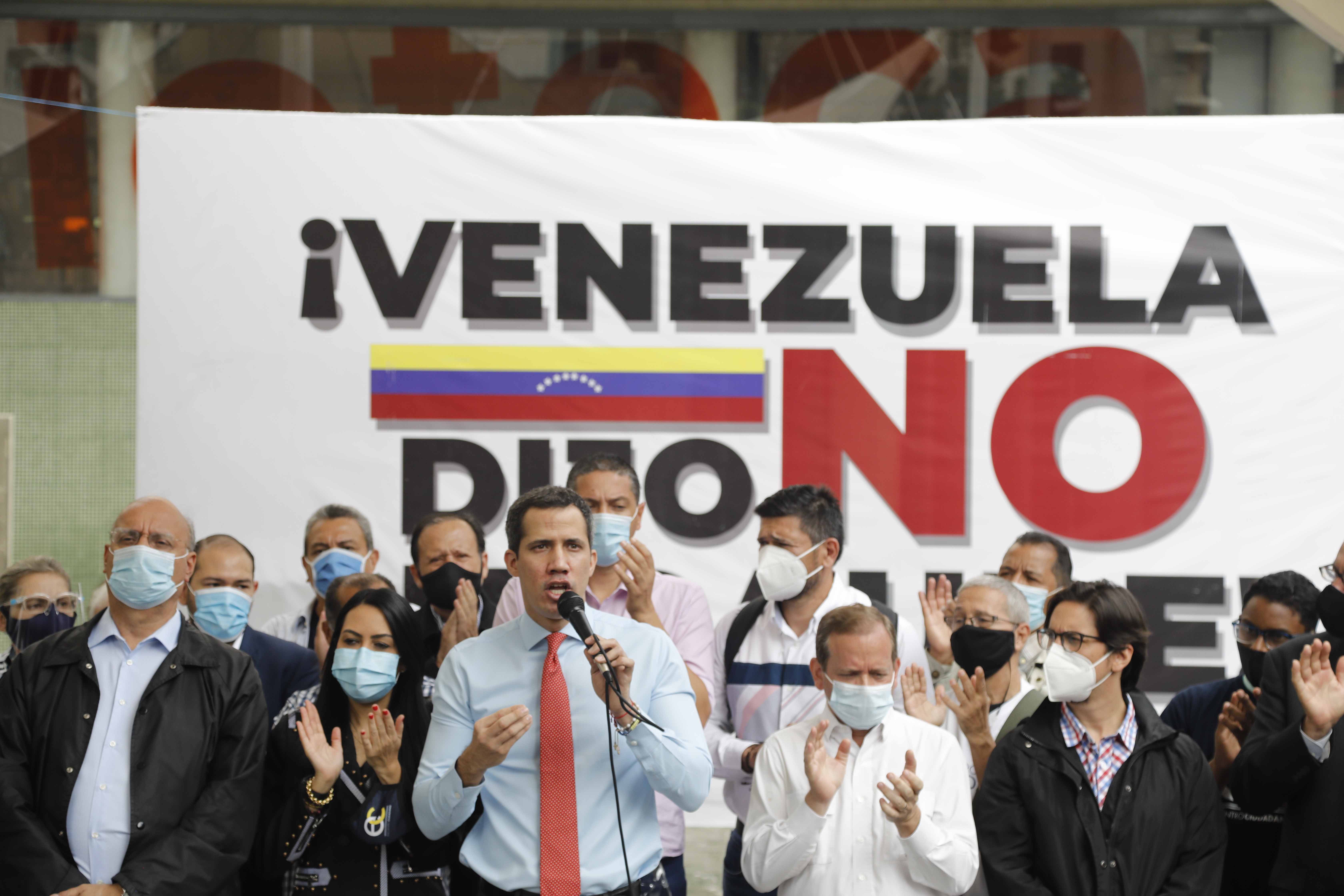 Flanked by party members, Venezuelan opposition leader Juan Guaido speaks during a press conference, a day after parliamentary elections, in Caracas, Venezuela, Monday, Dec. 7, 2020. Guaido rejected the results of Sunday's elections in which the government of President Nicolas Maduro declared victory in an election where the European Union said did not meet democratic standards and could not be considered credible
