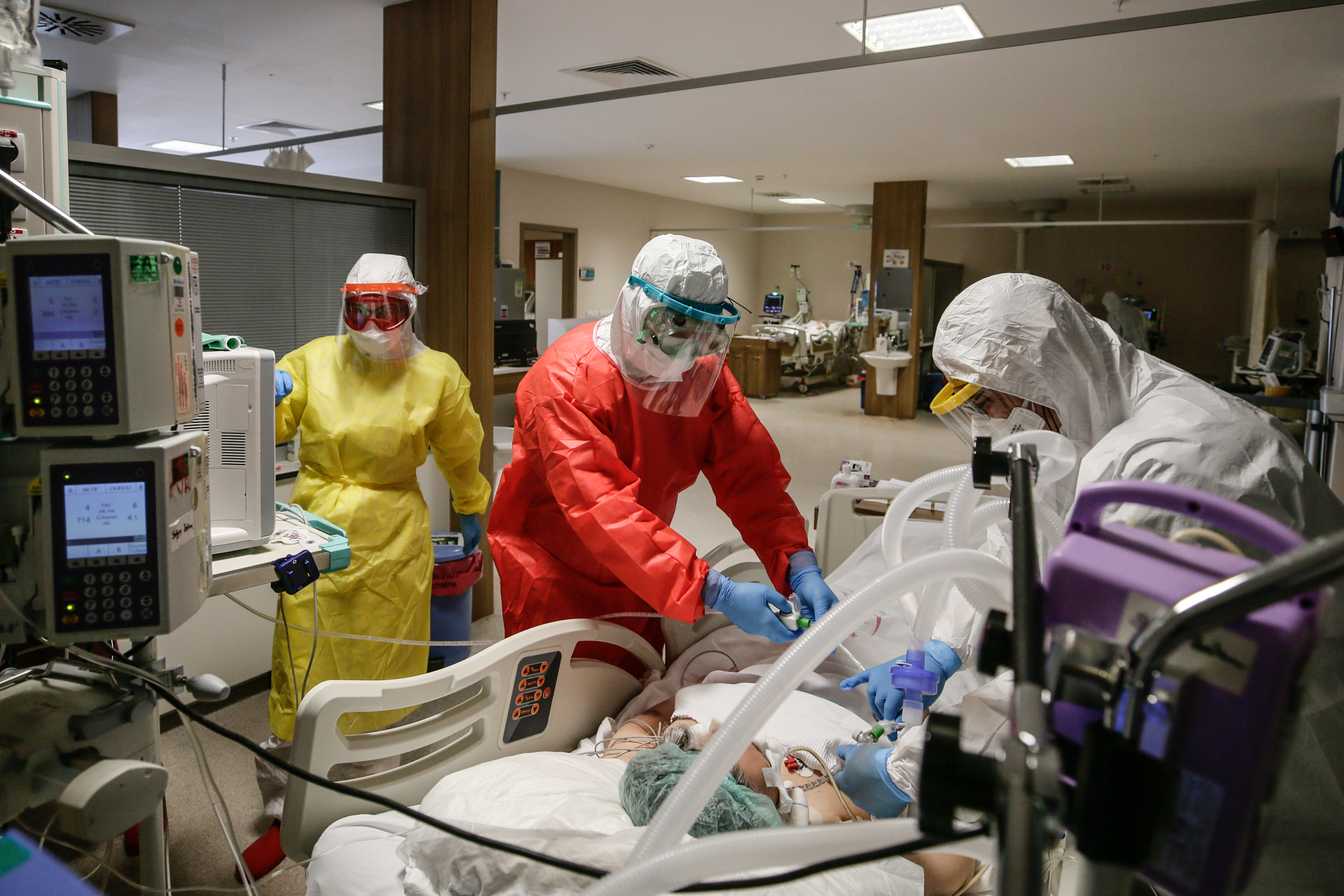 Healthcare workers wearing mask and protective suits take care of a patient at intensive care unit of Bornova Turkan Ozilhan State Hospital [File: Mahmut Serdar Alakus/Anadolu/Getty Images]
