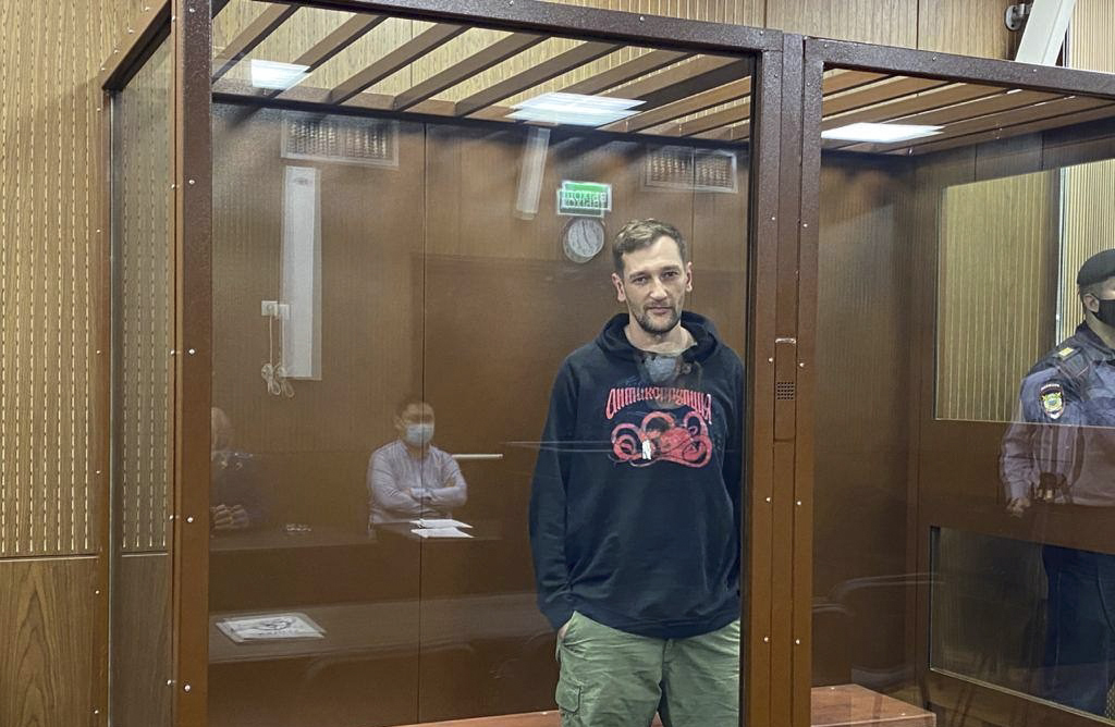 Oleg Navalny stands in a courthouse cage