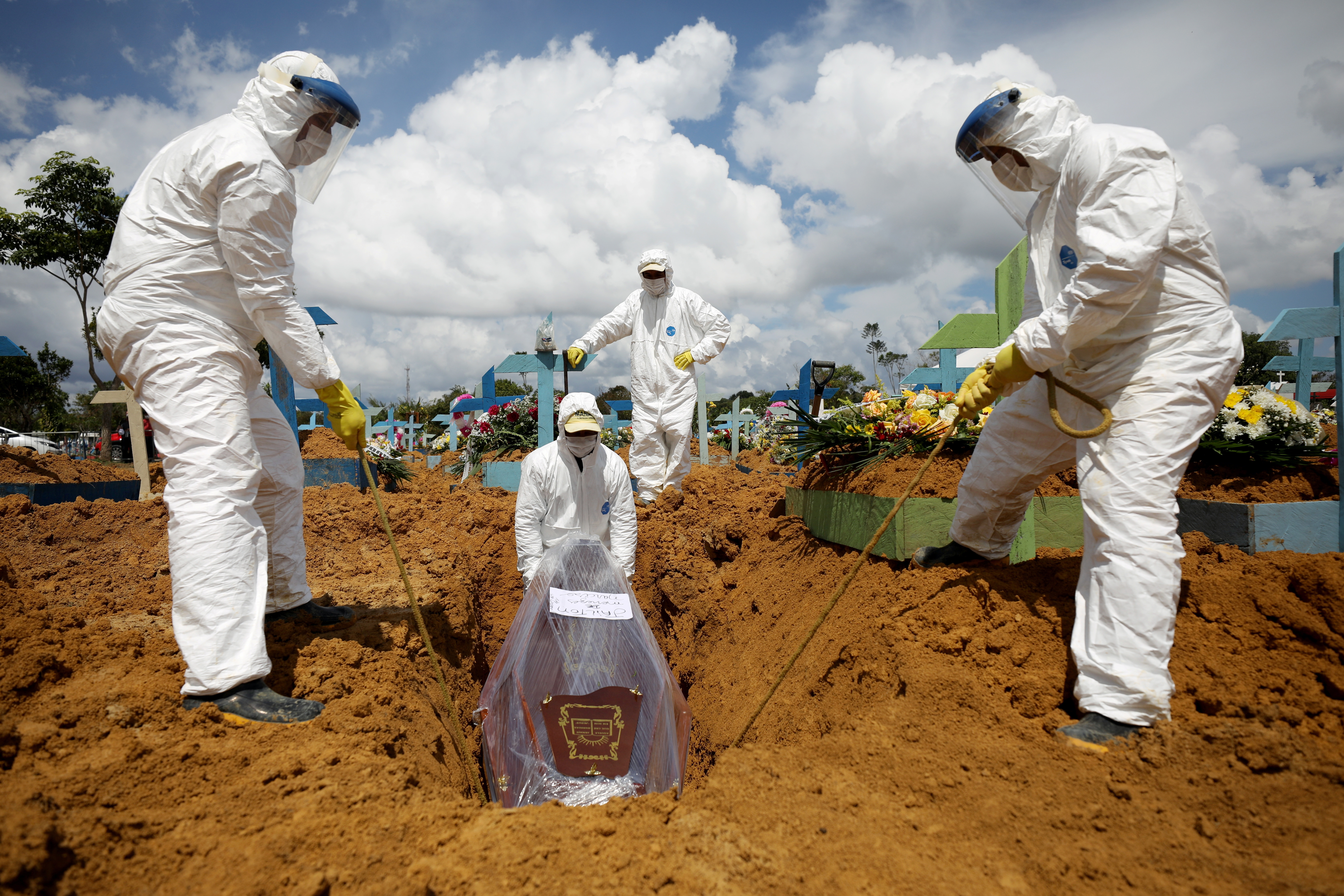 Gravediggers work during the burial of Jailton de Meneses, 43, who passed away due to COVID-19, at the Parque Taruma cemetery in Manaus, Brazil, on January 17 [Bruno Kelly/Reuters]