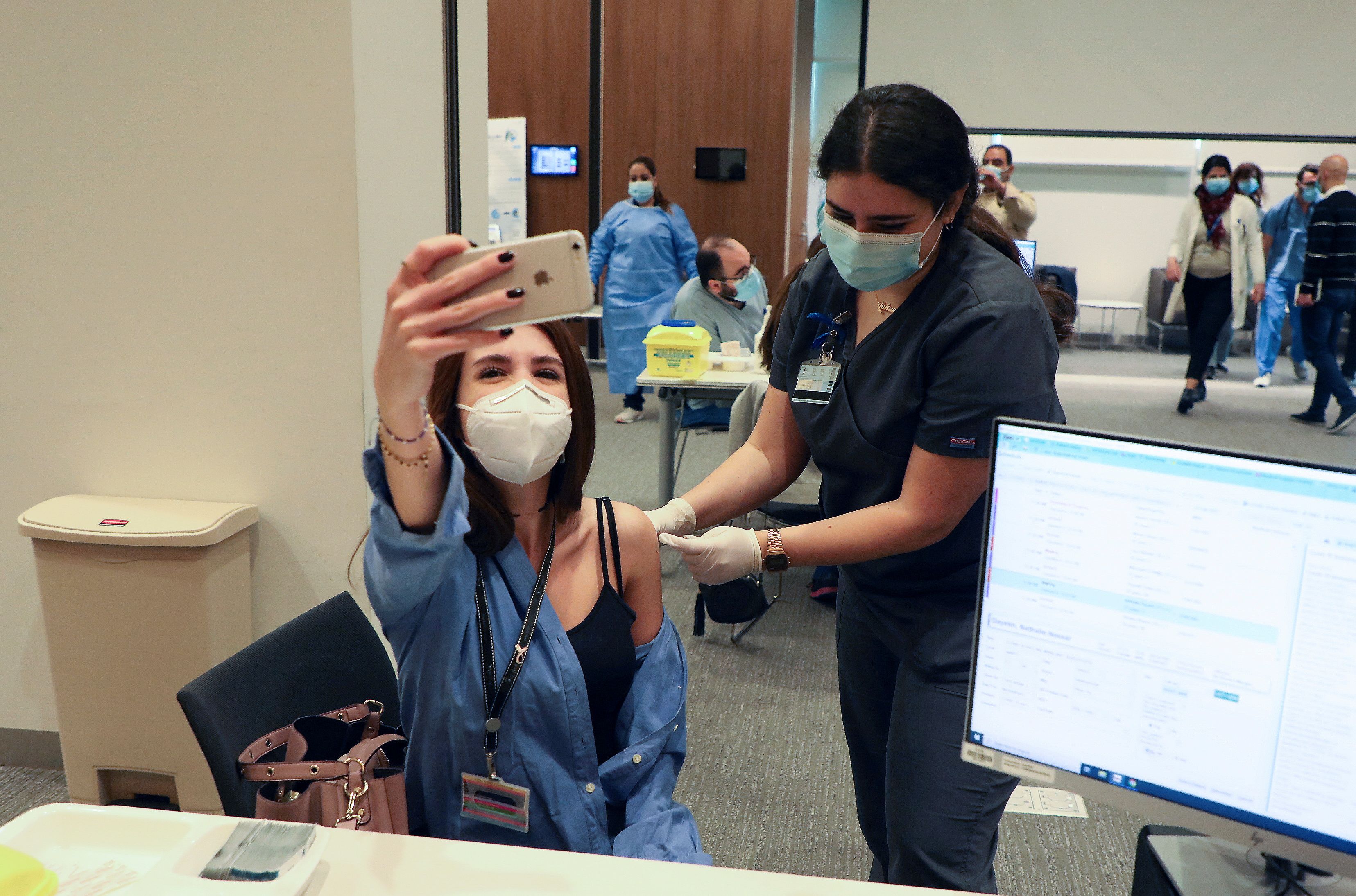 A woman receives the Pfizer-BioNTech vaccine at American University of Beirut's medical centre on Sunday [Mohamed Azakir/Reuters]