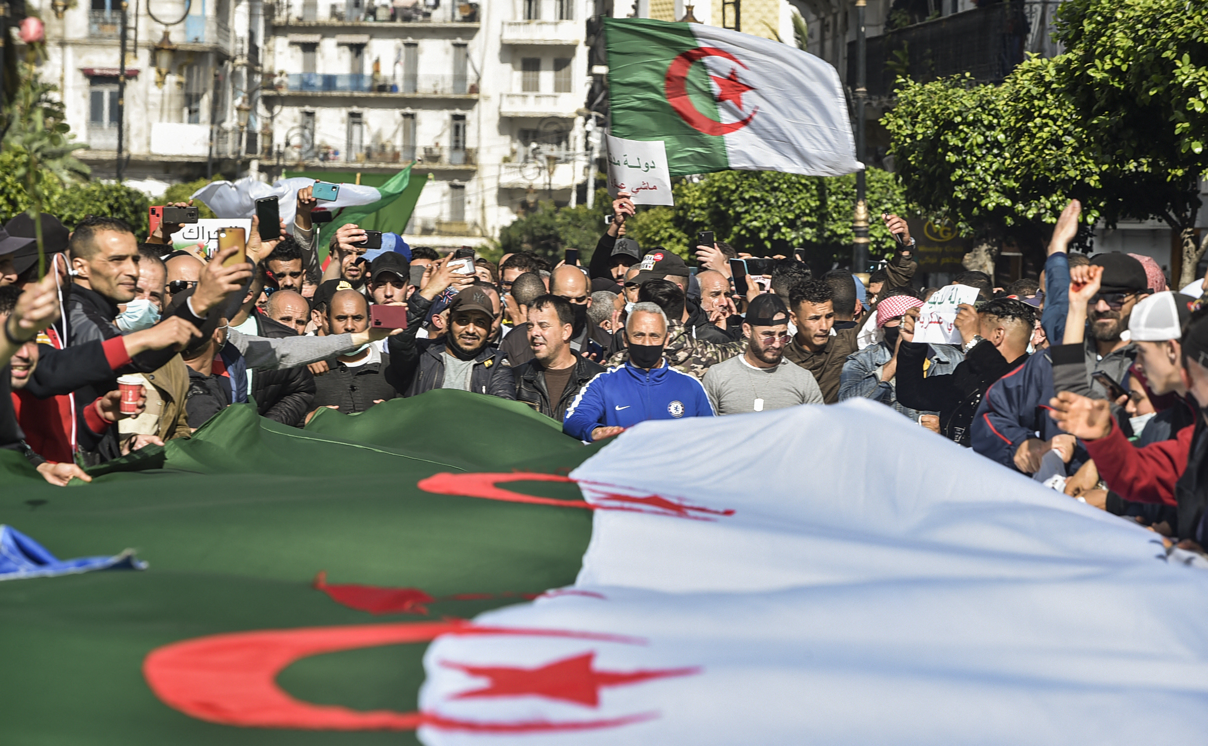 Algerians wave national flags during an anti-government protest in the capital Algiers on March 5, 2021. - Thousands of people demonstrated in Algiers and other cities across the country, confirming the remobilization of the Hirak protest movement again in the streets since the second anniversary of the uprising on February 22. (Photo by RYAD KRAMDI / AFP)