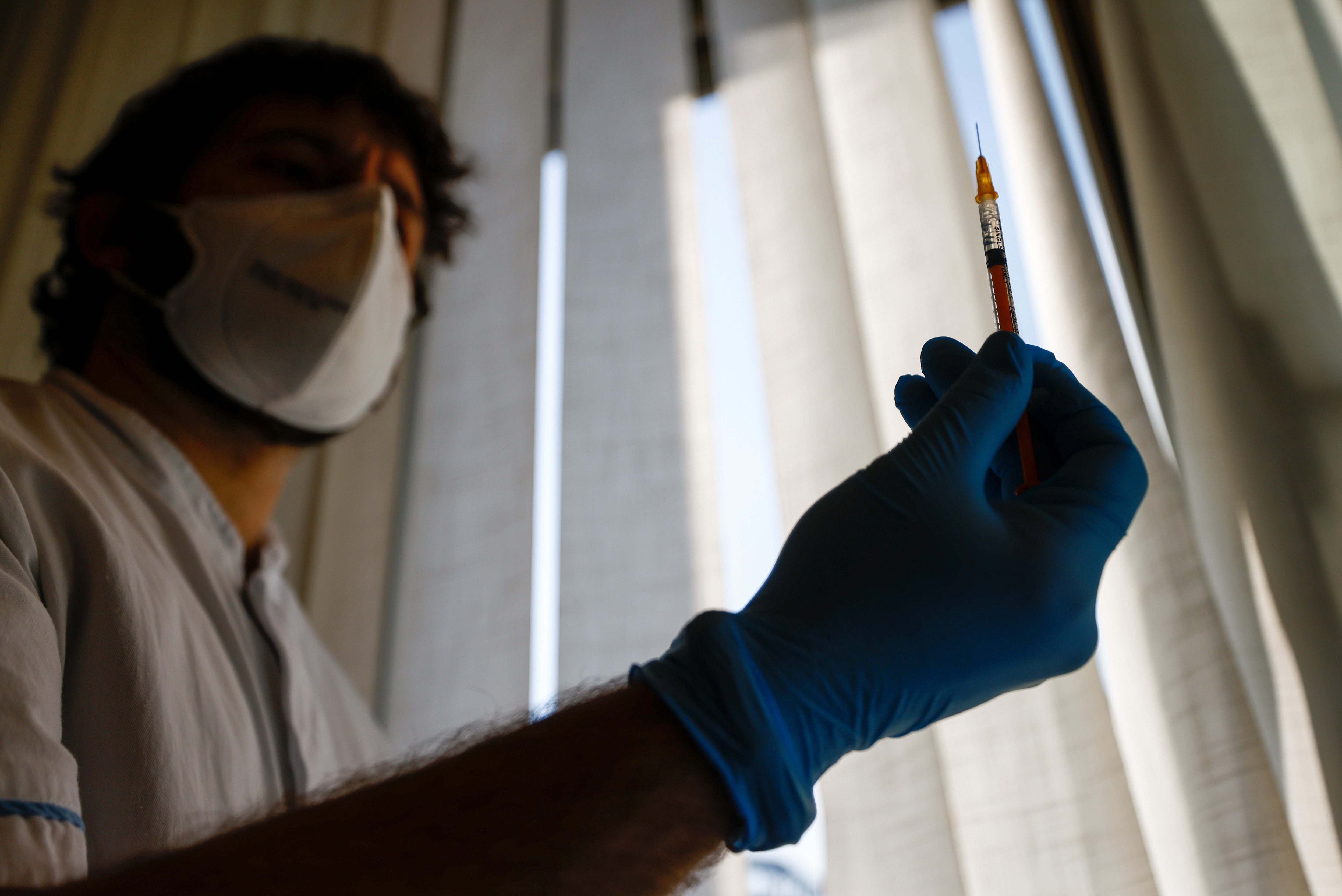 A man with a syringe in his right hand