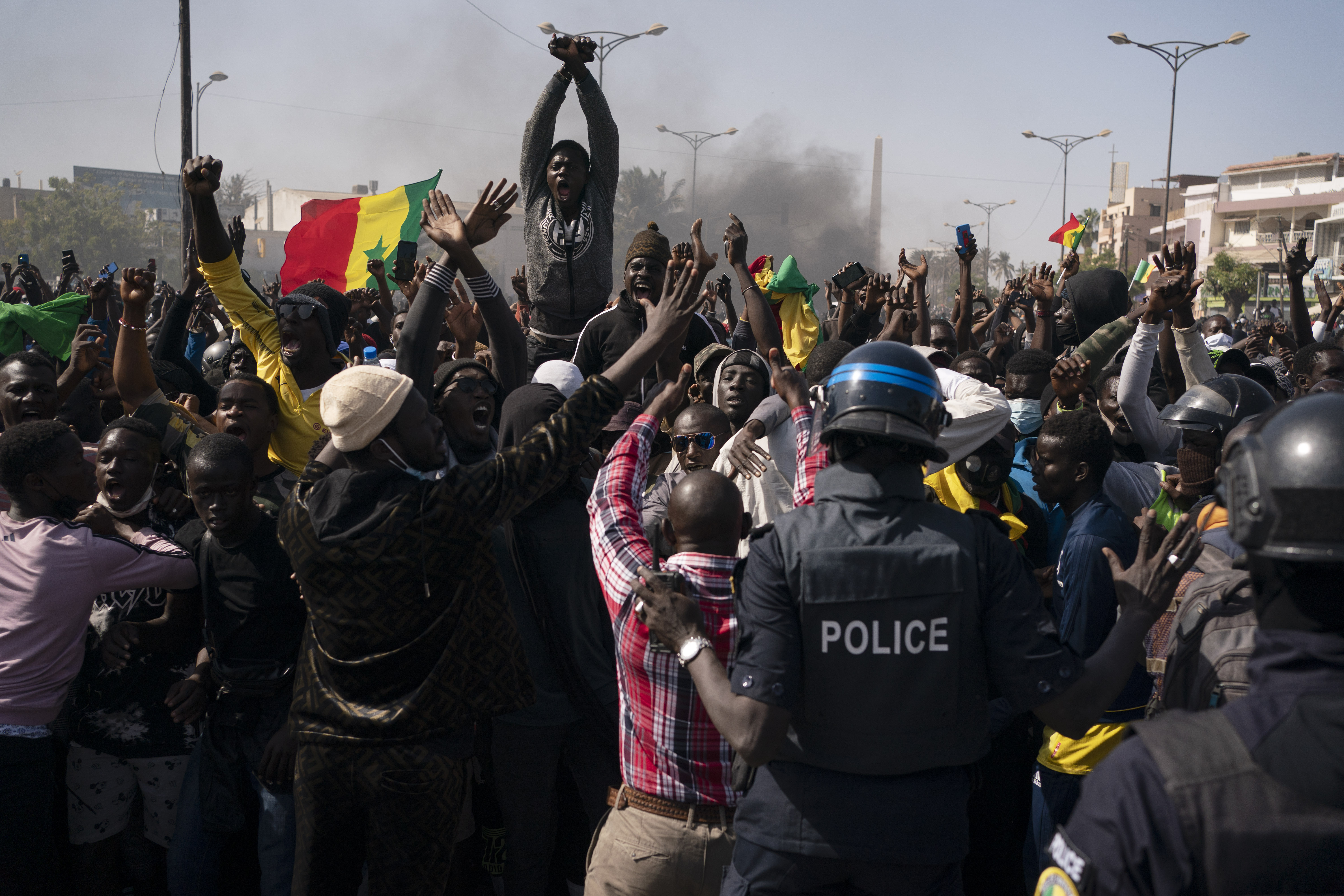 Demonstrators shout slogans in front of riot policemen during a protest against the arrest of opposition leader and former presidential candidate Ousmane Sonko, Senegal, Monday, March 8, 2021 [Leo Correa/AP Photo]