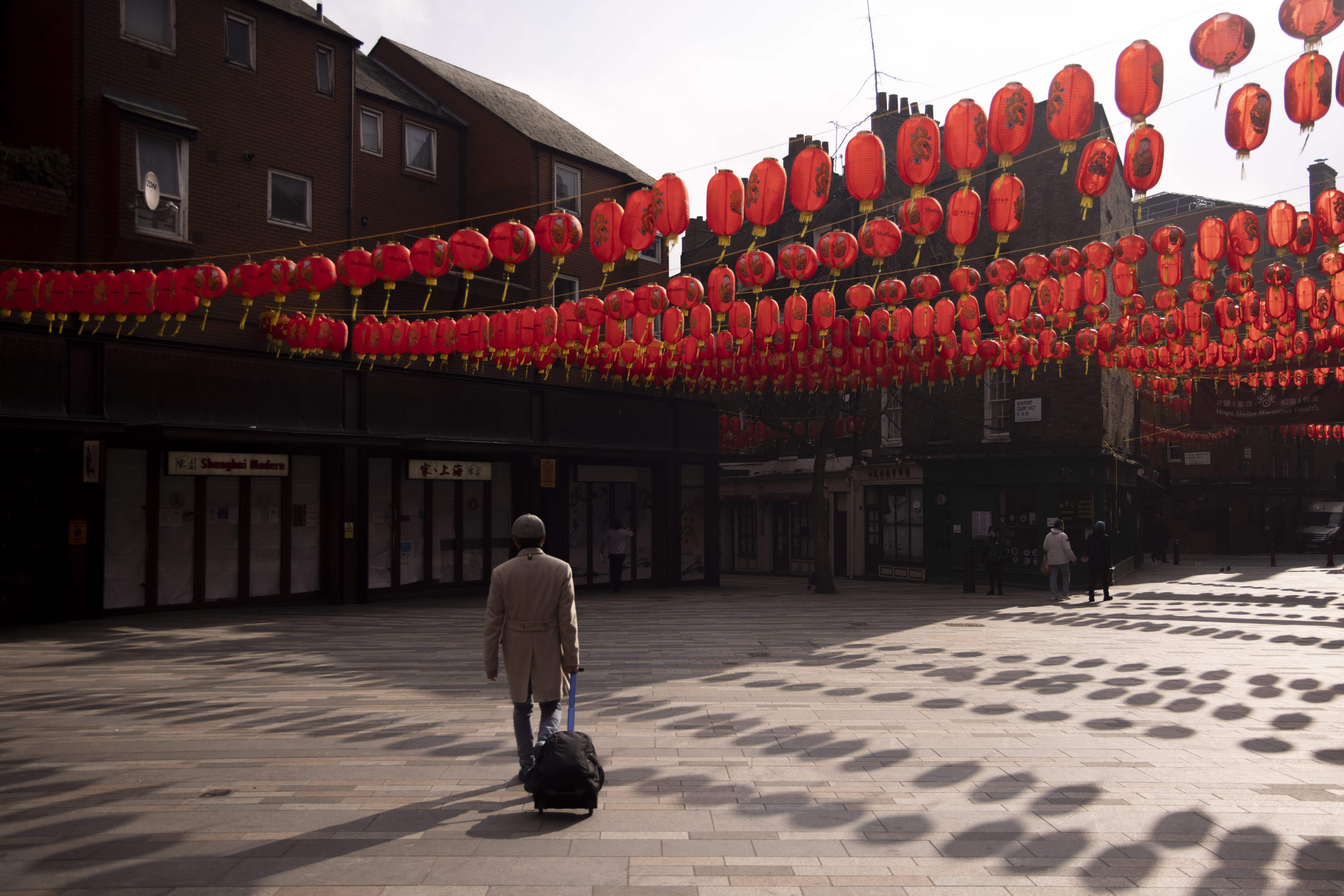 Pedestrians walk past closed restaurants in Chinatown in London, UK, on March 1, 2021 [Jason Alden/Bloomberg via Getty Images]