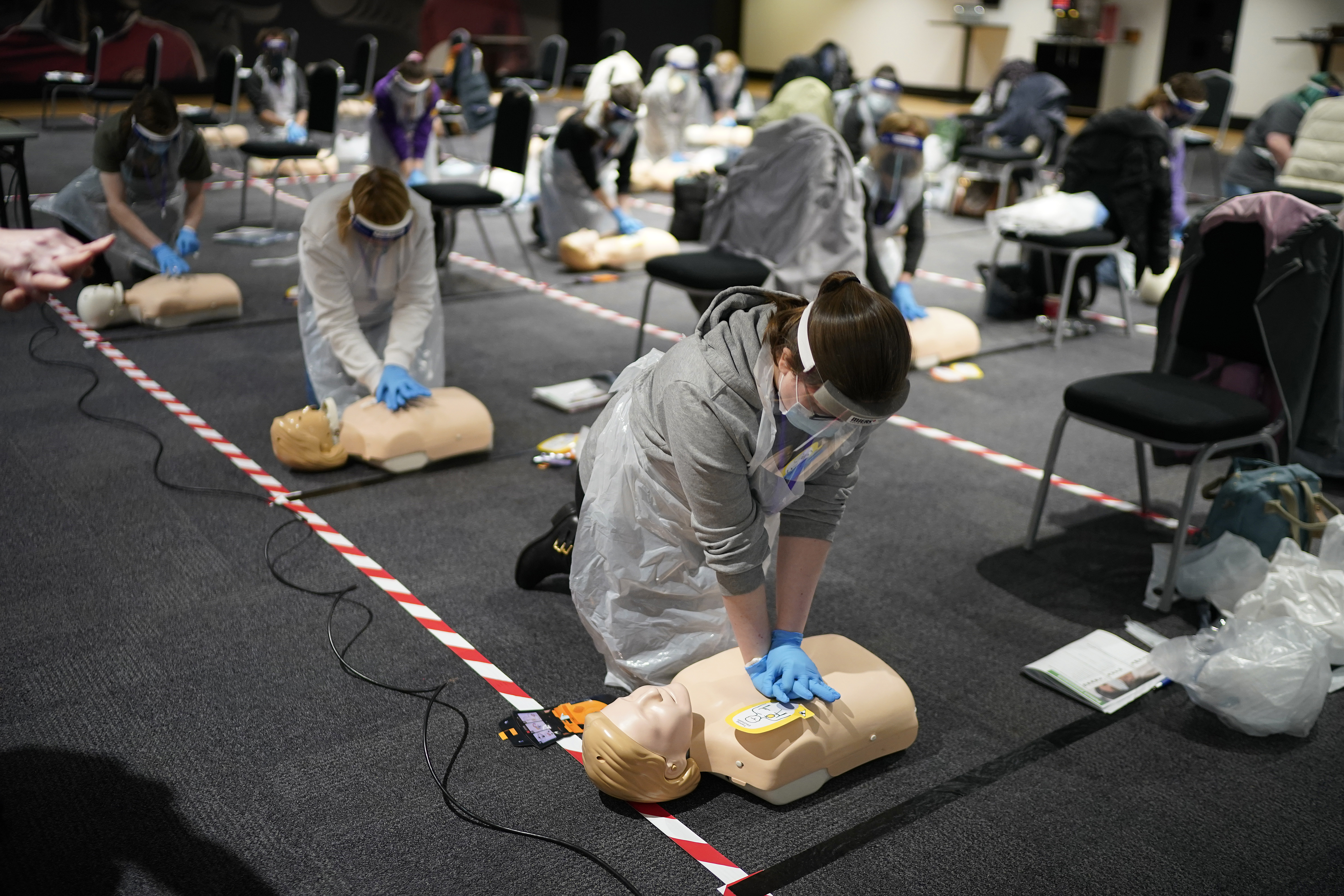 British volunteers learn CPR by training on dummies.