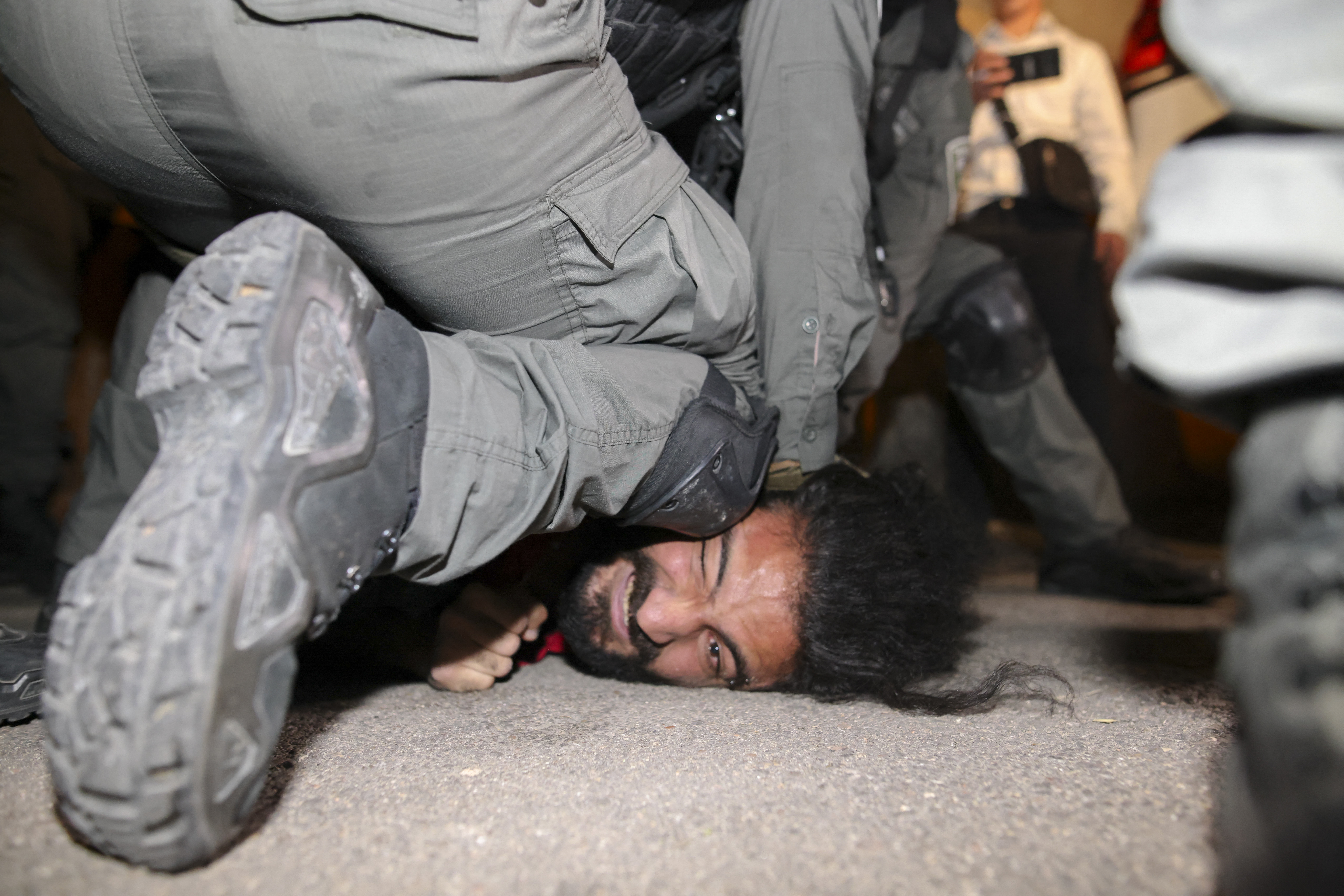 Israeli security forces detain a Palestinian man, as they crack down on a protest in solidarity with Palestinian families who face forced eviction in the Sheikh Jarrah neighbourhood of occupied East Jerusalem, on May 4, 2021 [AFP/Ahmad Gharabli]