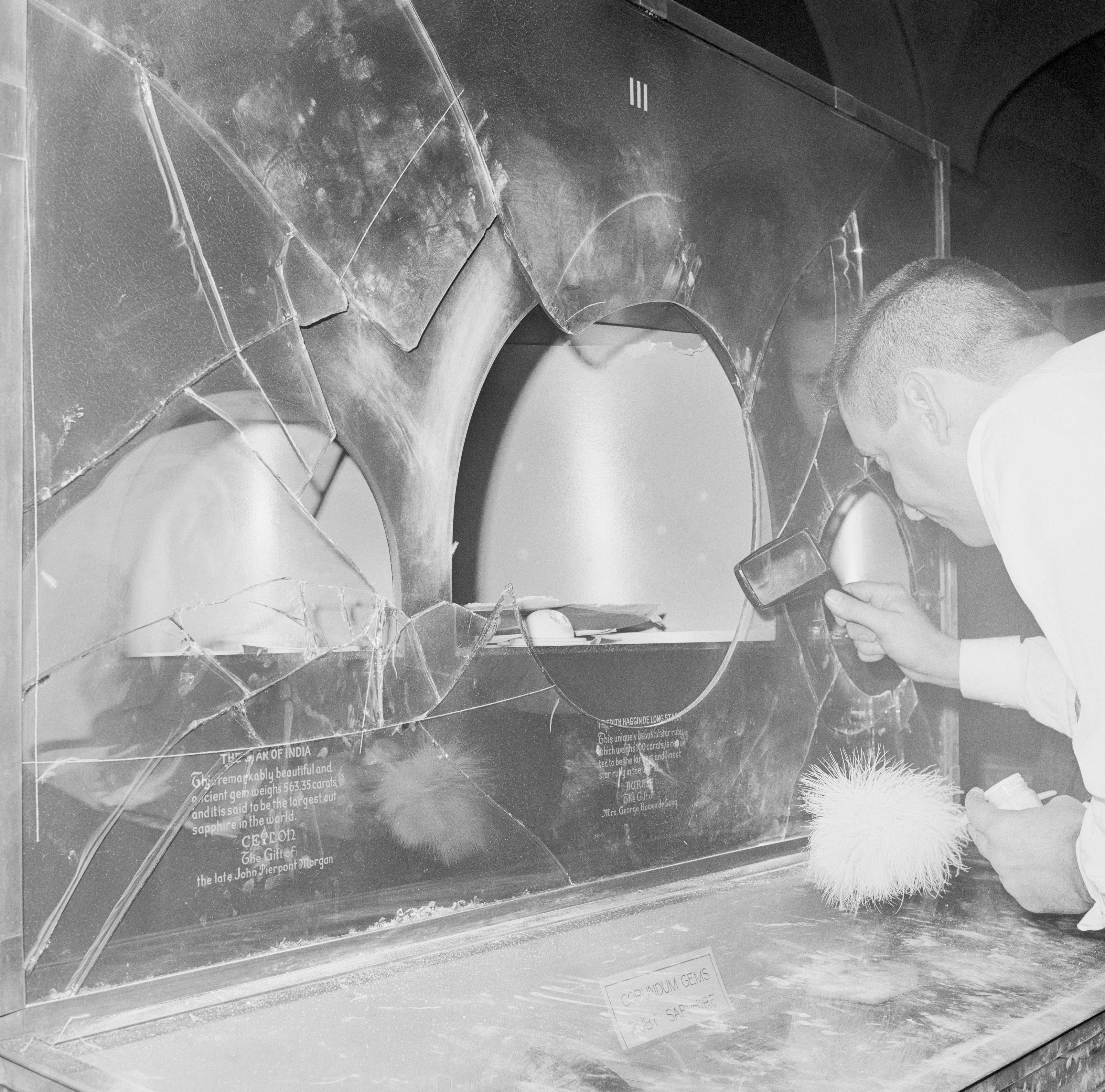 A policeman dusts for fingerprints after Jack Roland Murphy, Allan Kuhn and Roger Clark stole $3m worth of gems from the Museum of Natural History in 1964 [File: Getty Images]