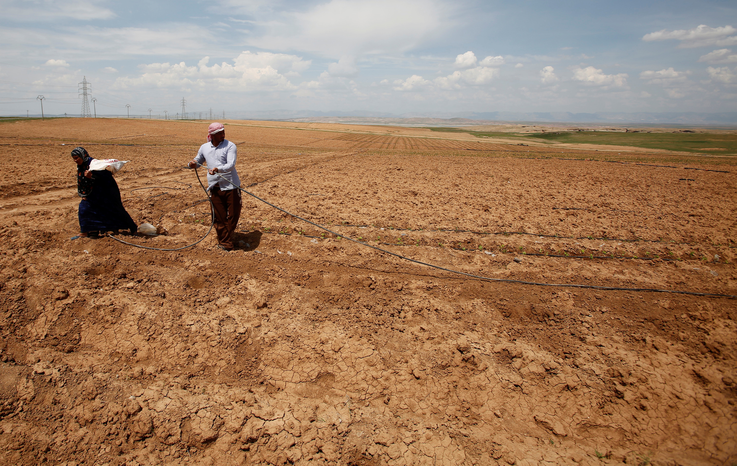 Iraqi farmers work in their fields in northern Iraq’s Nineveh Plains [File: Khalid al-Mousily/Reuters]
