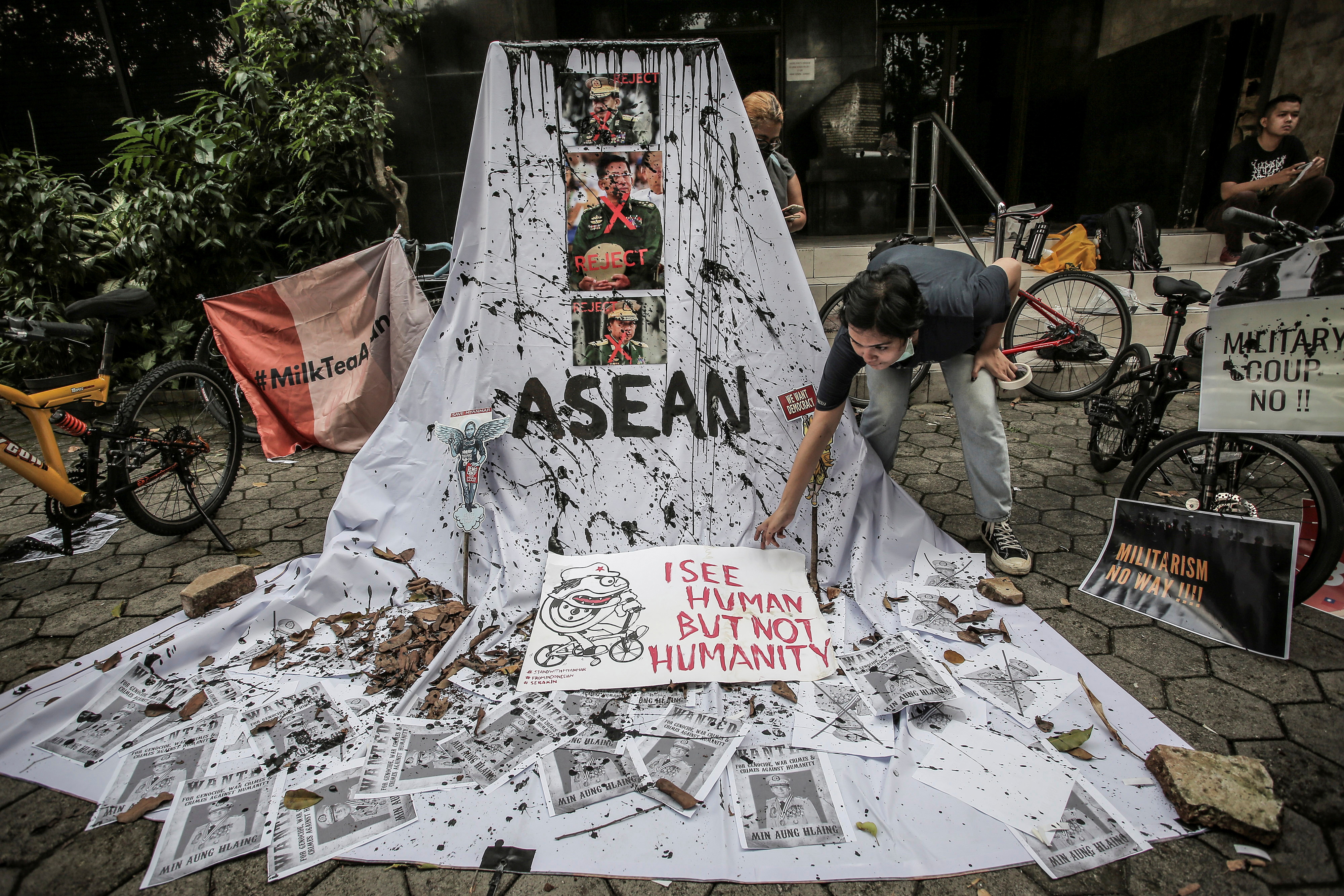 A woman prepares a placard from crossed out portraits of Myanmar's military chief Senior General Min Aung Hlaing during protests against the military coup in Myanmar, in Jakarta, Indonesia, on April 24, 2021 [Antara Foto/Dhemas Reviyanto/ via Reuters]