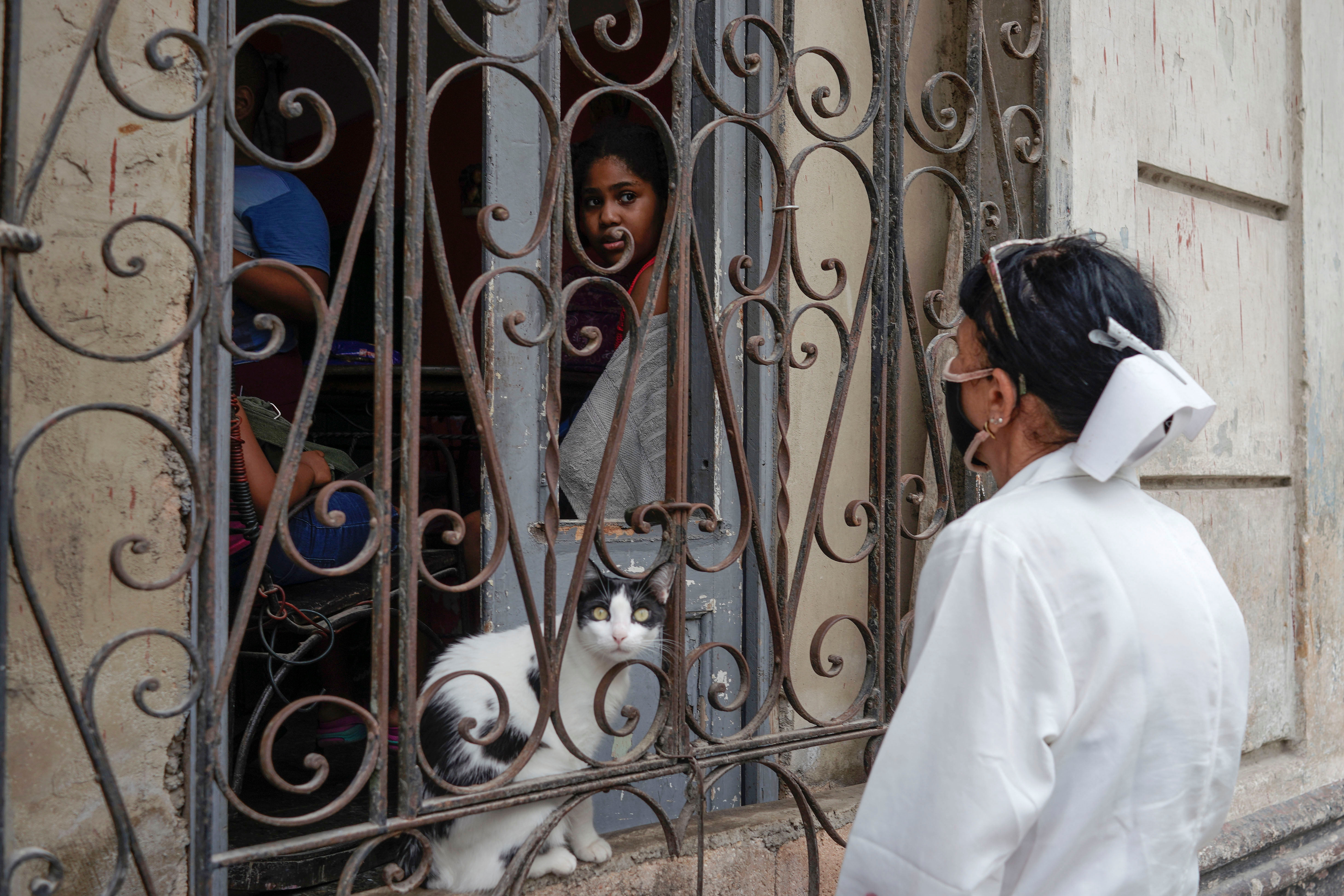 A nurse asks a family to get COVID-19 jabs at a vaccination centre amid concerns about the spread of the virus, in Havana, Cuba, on June 17 [Alexandre Meneghini/Reuters]