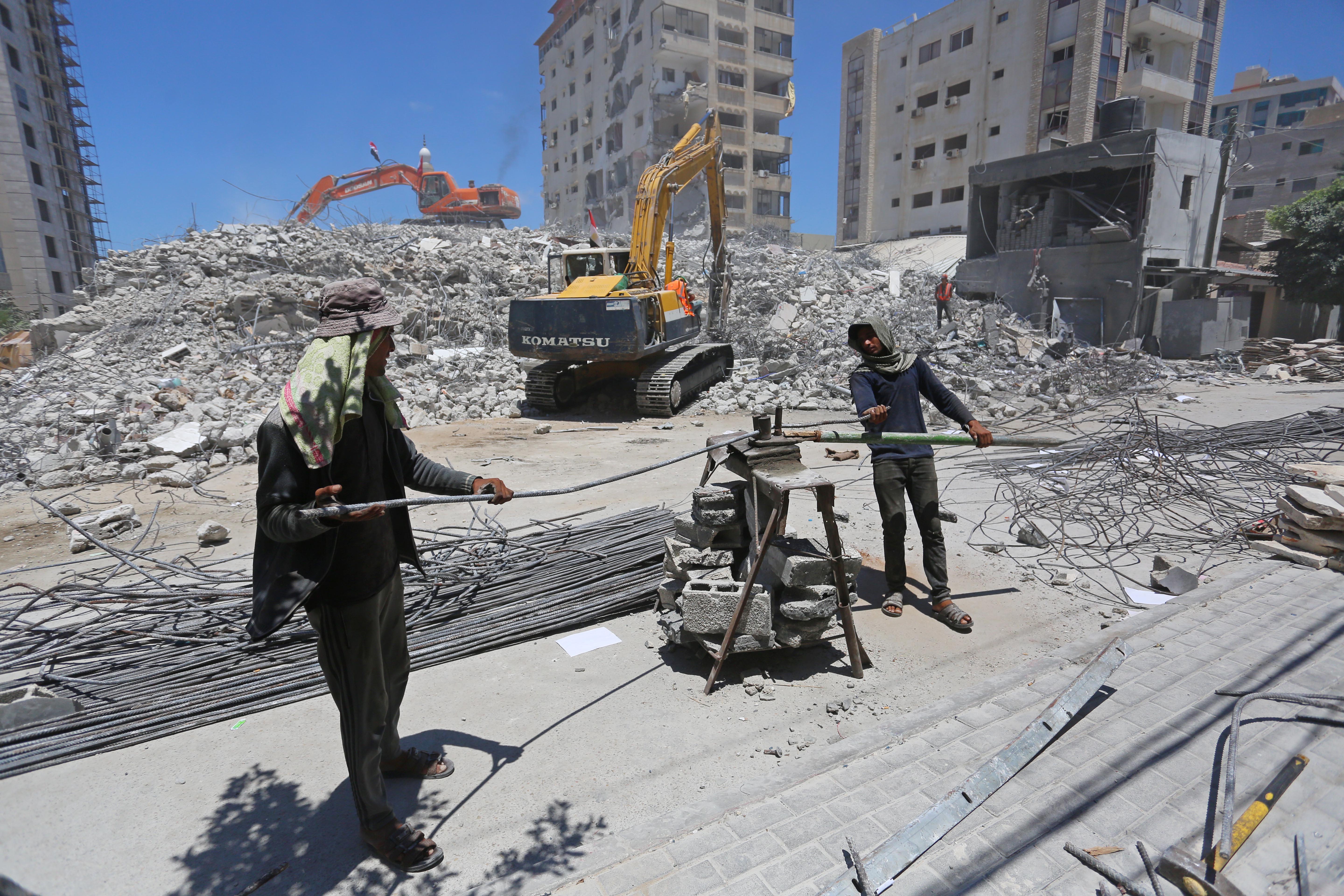 Palestinian workers modify steel rods for the construction of buildings destroyed by Israeli fighter jets during the recent attacks on the Gaza Strip [Ashraf Amra/Al Jazeera]