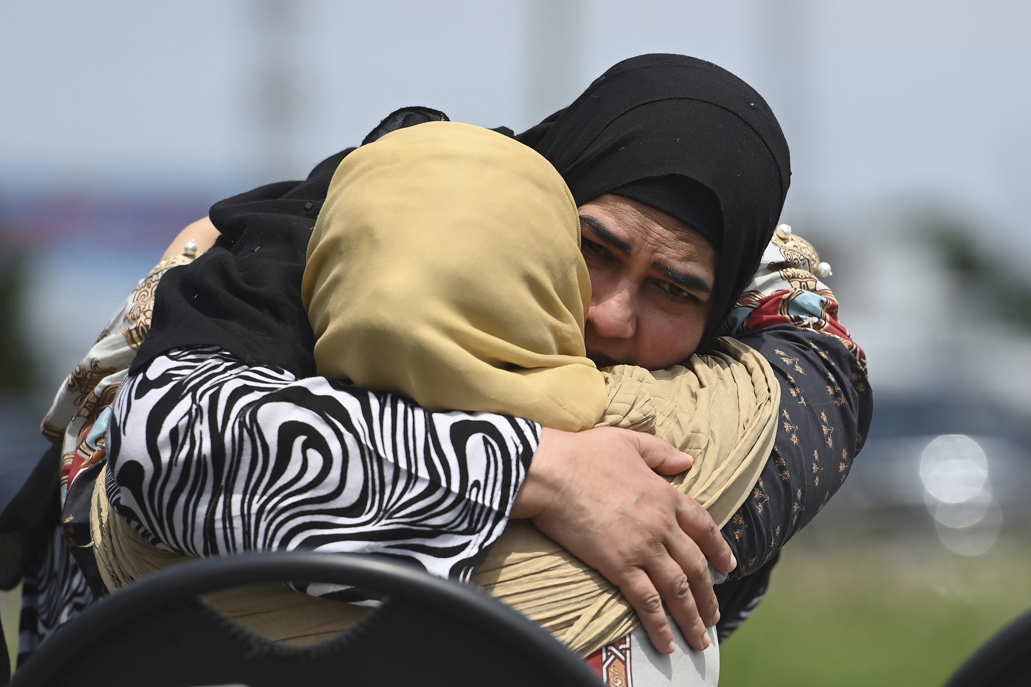 Family members comfort each other at the Islamic Centre of Southwest Ontario in London, Ontario, on June 12, 2021 during the funeral service for the four members of the Afzaal family killed in a targeted Islamophobic attack [Nathan Denette/The Canadian Press via AP, Pool]