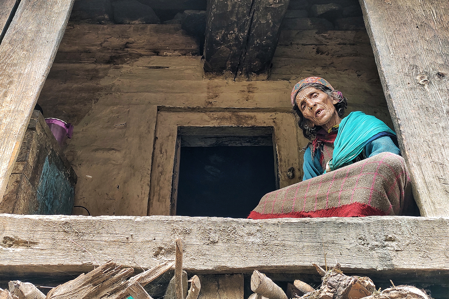 Malana resident Bhudhi Devi chanting the name of the local deity at her house [Srishti Jaswal/Al Jazeera]